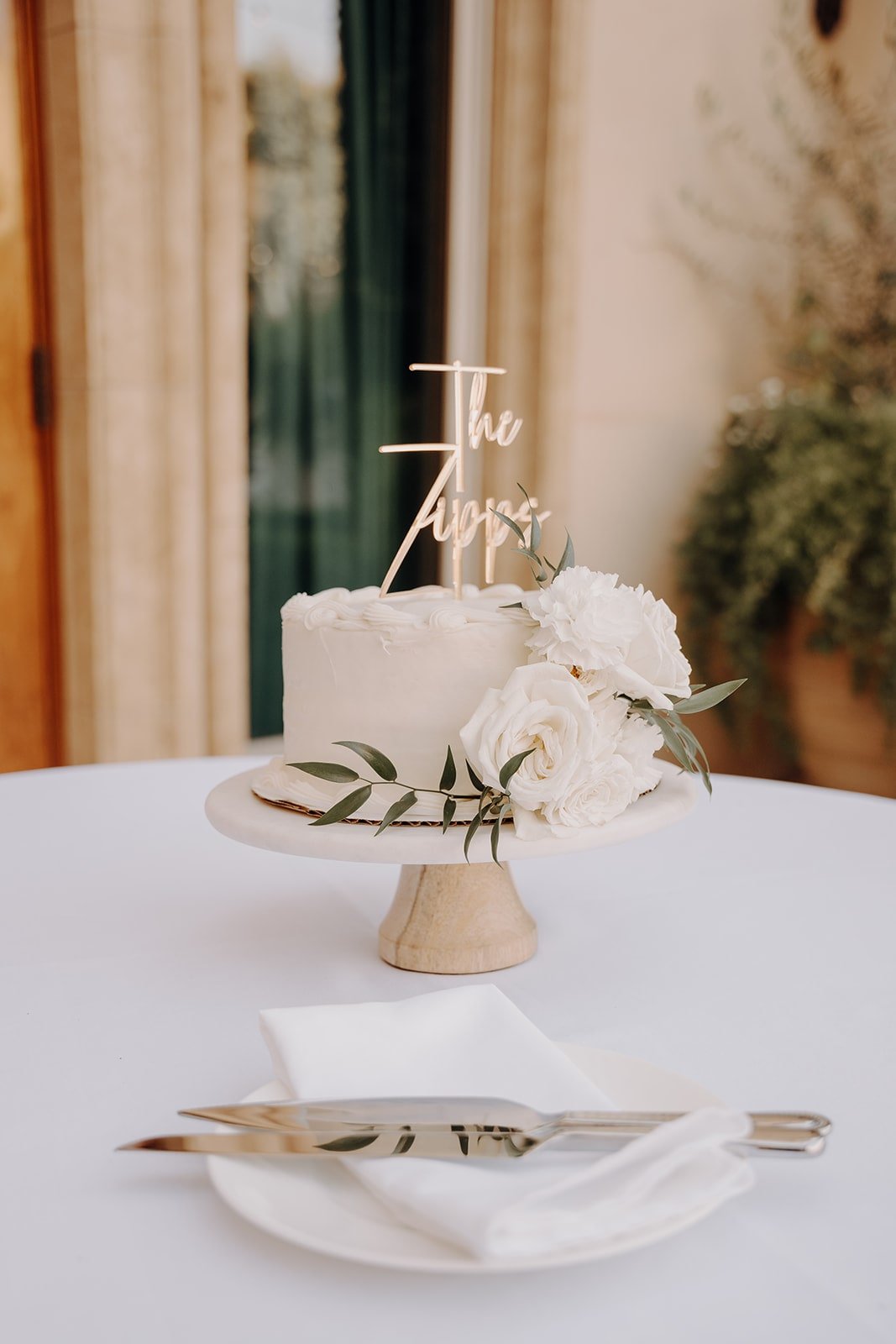 White wedding cake with custom gold cake topper