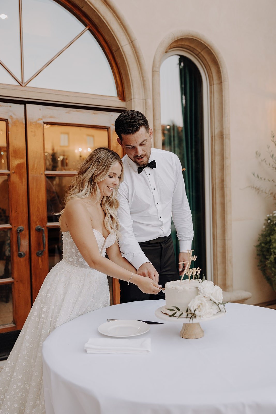 Bride and groom cut the cake at their Tuscan wedding reception in California