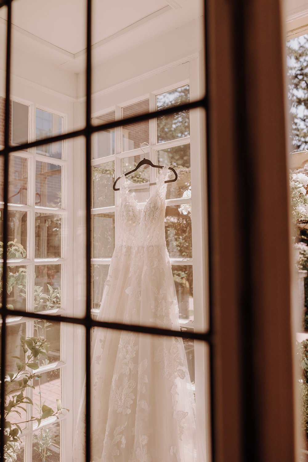 White wedding dress hanging from the window at Lairmont wedding venue in Washington