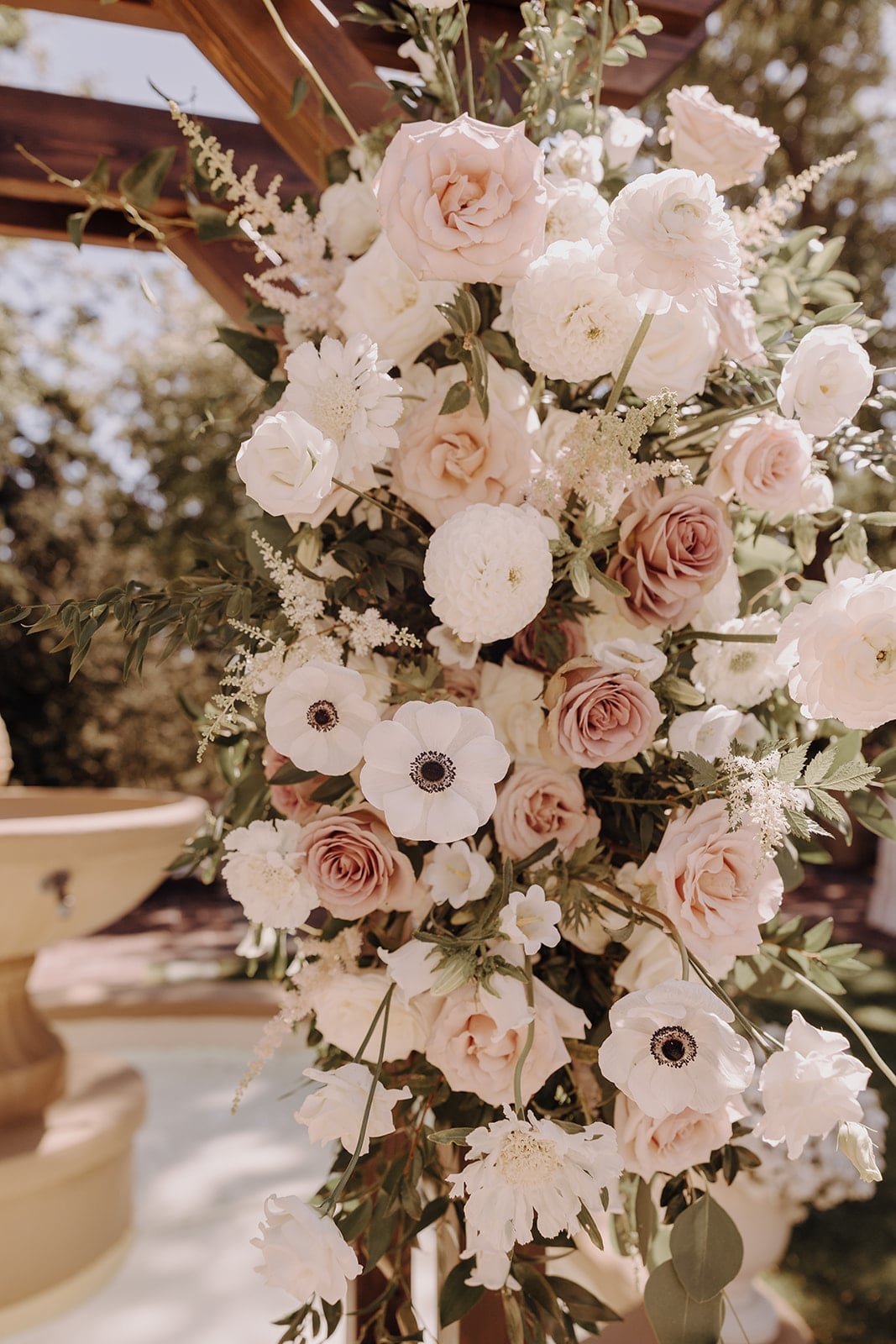 White and blush wedding flowers on ceremony arch at Lairmont Manor