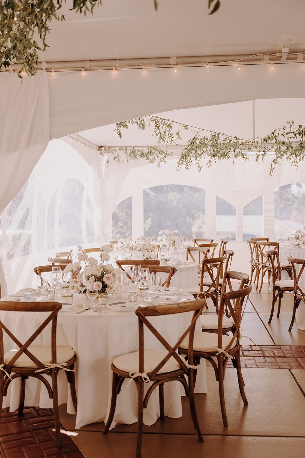 White reception tables with wood chairs and white cushions at Lairmont Manor wedding