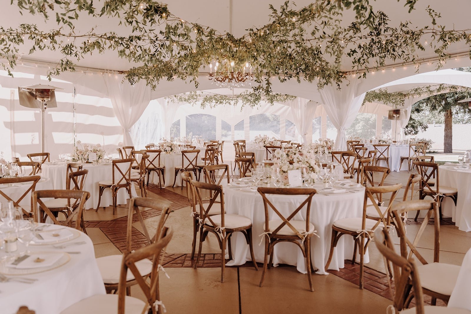 White reception tables with wood chairs and white cushions at Lairmont Manor wedding