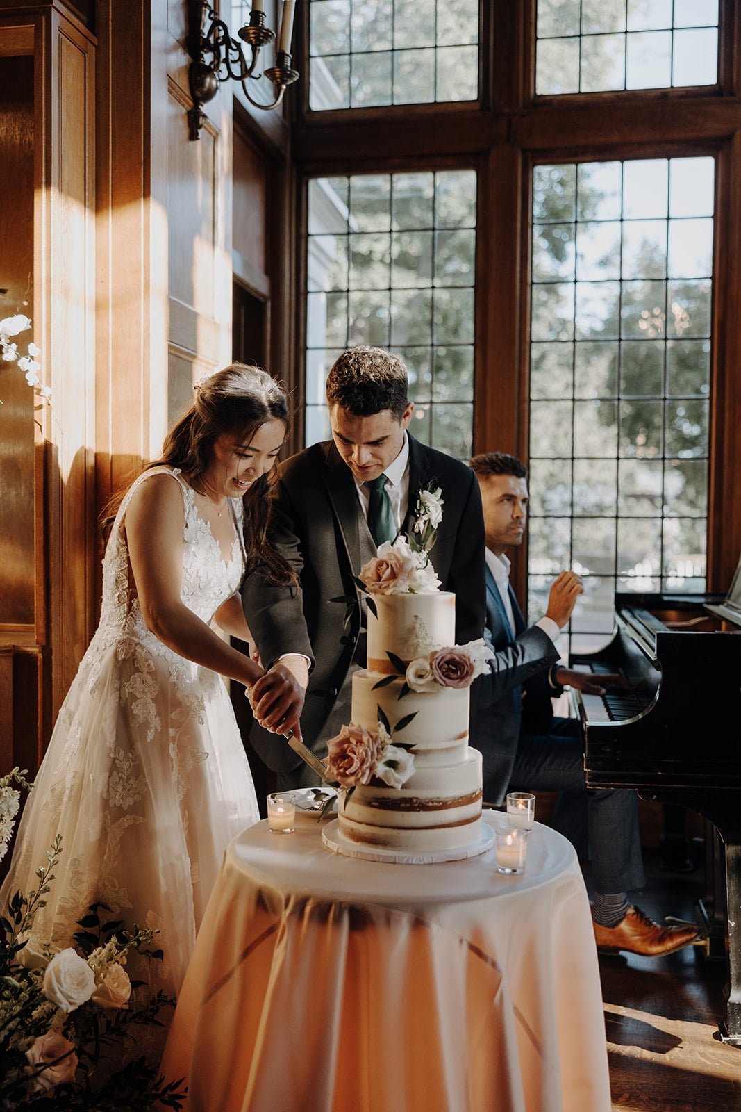 Bride and groom cut three tier white wedding cake at Lairmont Manor wedding in Washington