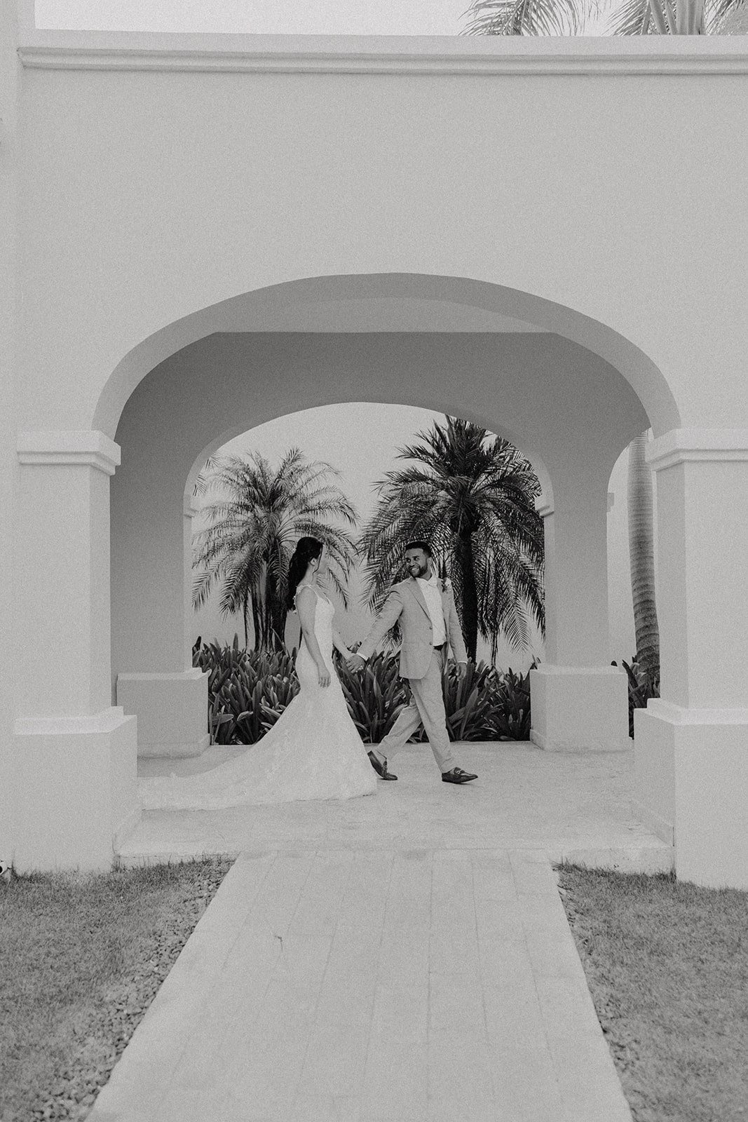 Bride and groom walk around Dreams Royal Beach Punta Cana during their wedding photos