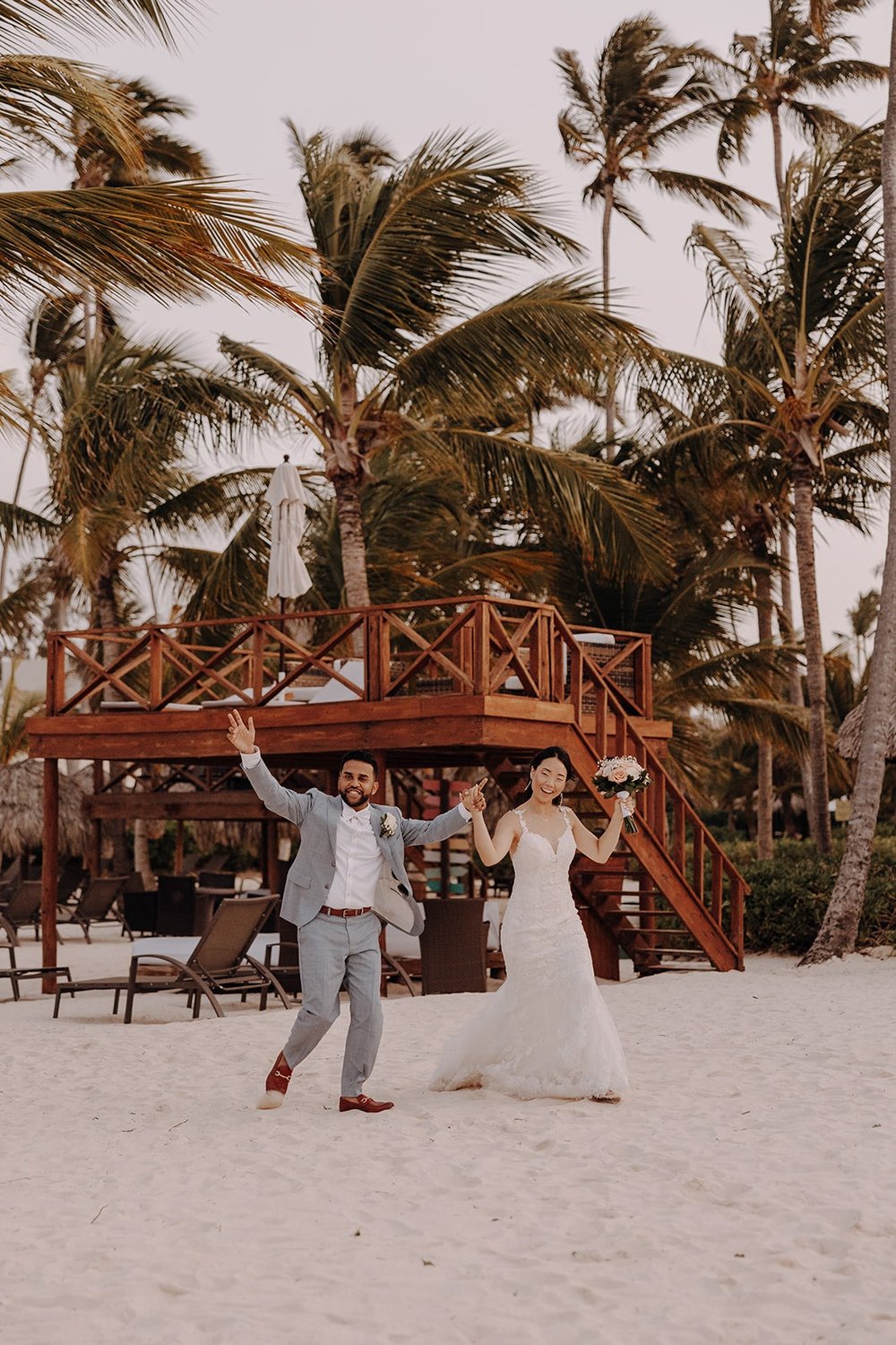 Bride and groom enter their beach wedding reception at Dreams Royal Beach Punta Cana
