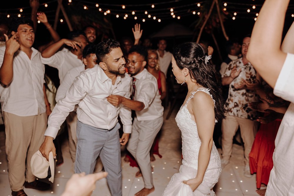 Bride and groom dance on the dance floor with their guests at their destination wedding