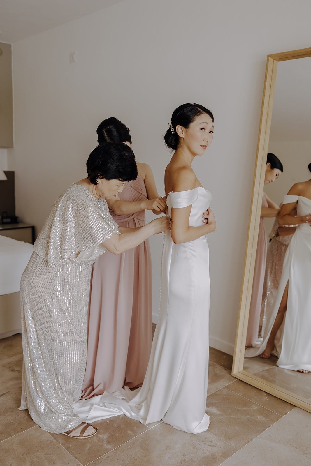 Bride gets zipped into her white Jenny Yoo dress