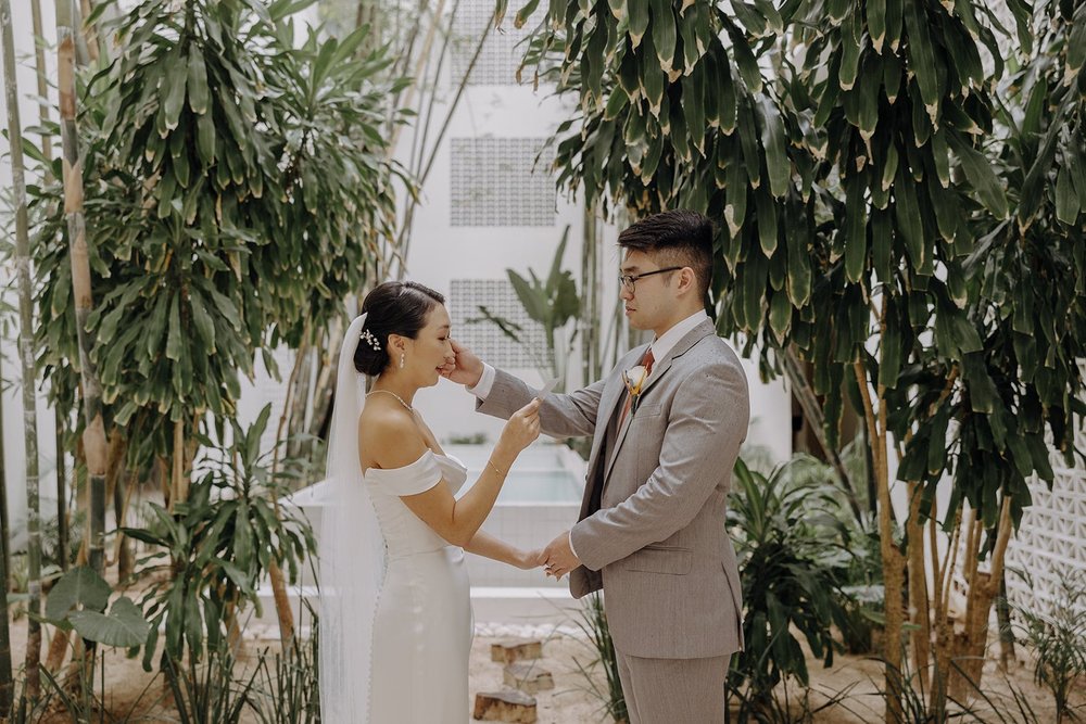 Bride and groom wipe each other's tears during personal vows at their Mexico resort wedding