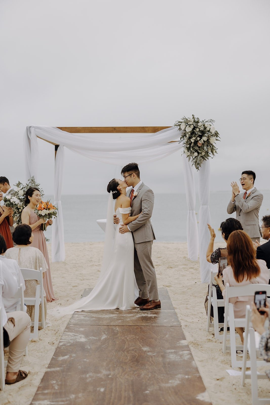 Bride and groom kiss during their Mexico resort wedding ceremony on the beach
