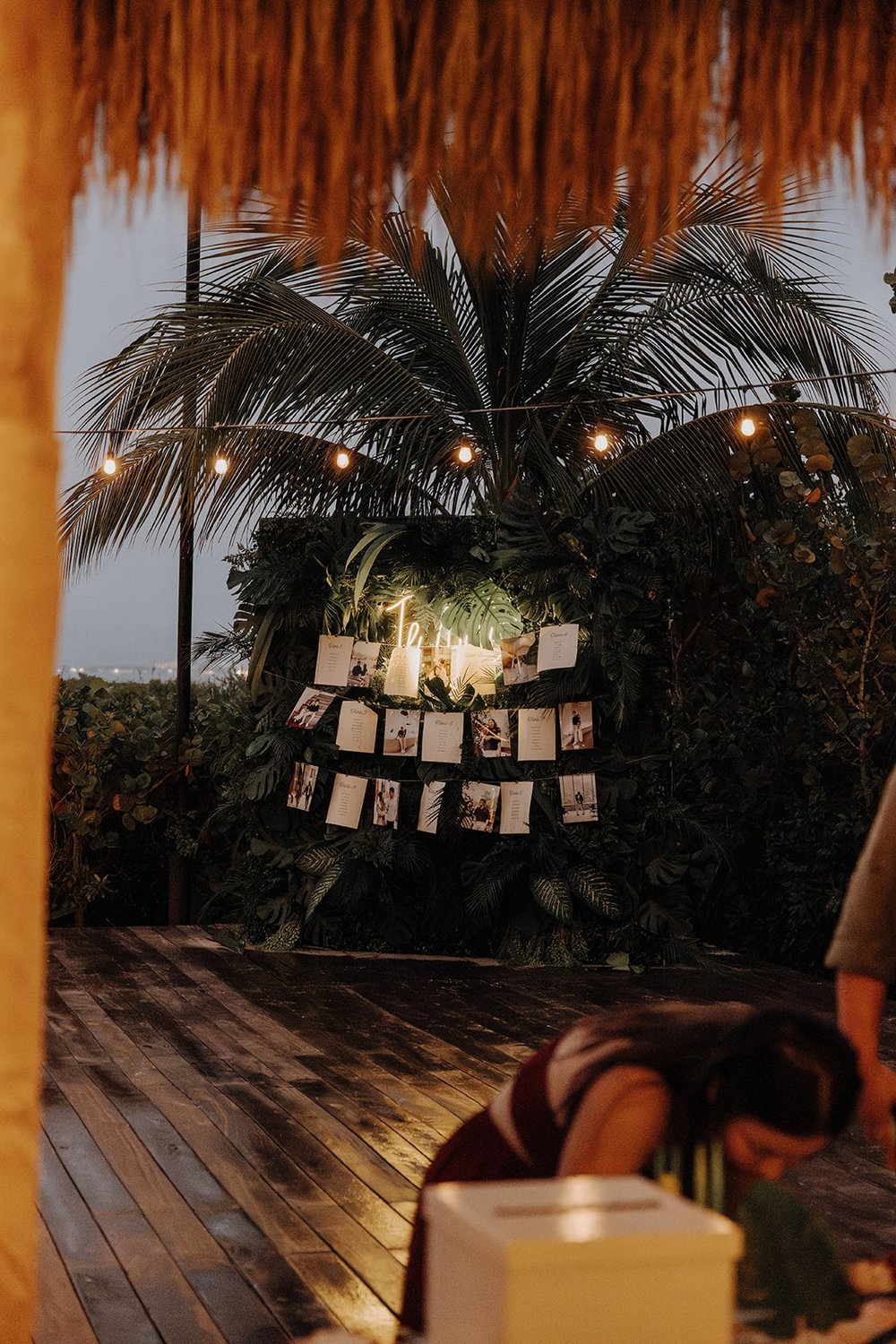 Reception photo wall with neon sign and string lights