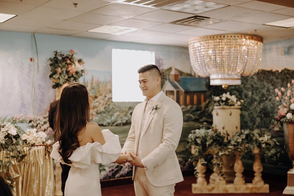 Bride and groom hold hands at their altar during their elopement at the Little White Chapel