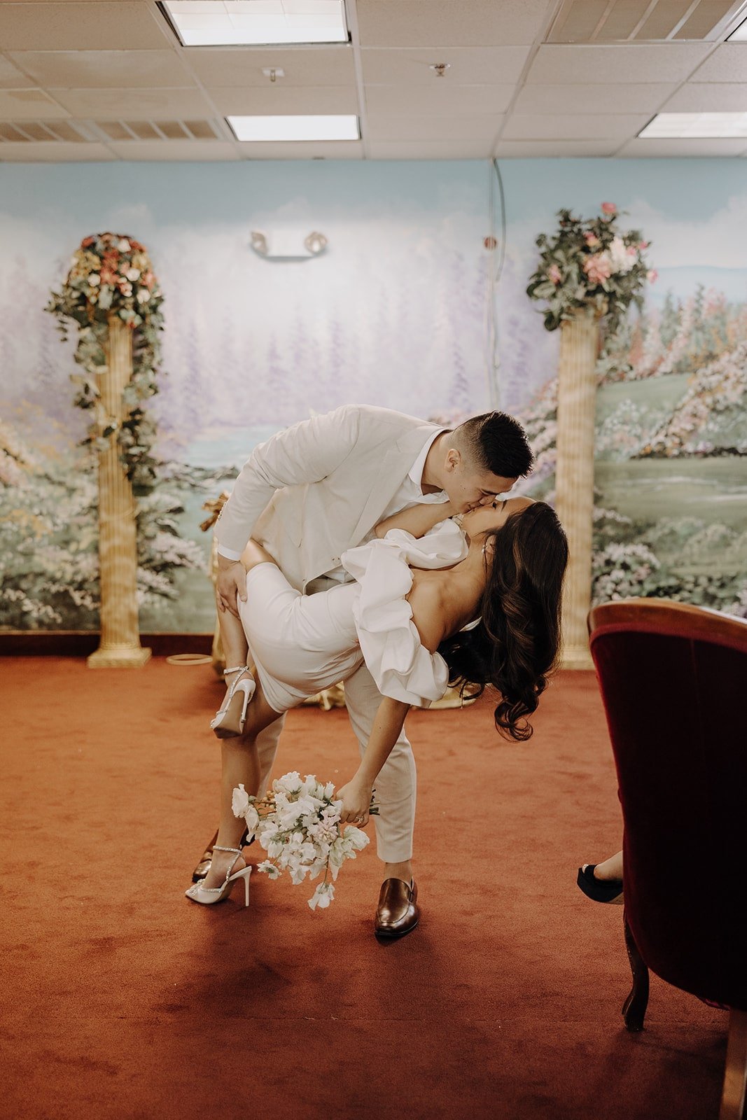 Groom dips bride for a kiss at their Las Vegas elopement at the Little White Chapel