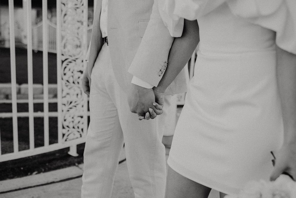 Bride and groom hold hands during their Las Vegas elopement at the Little White Chapel