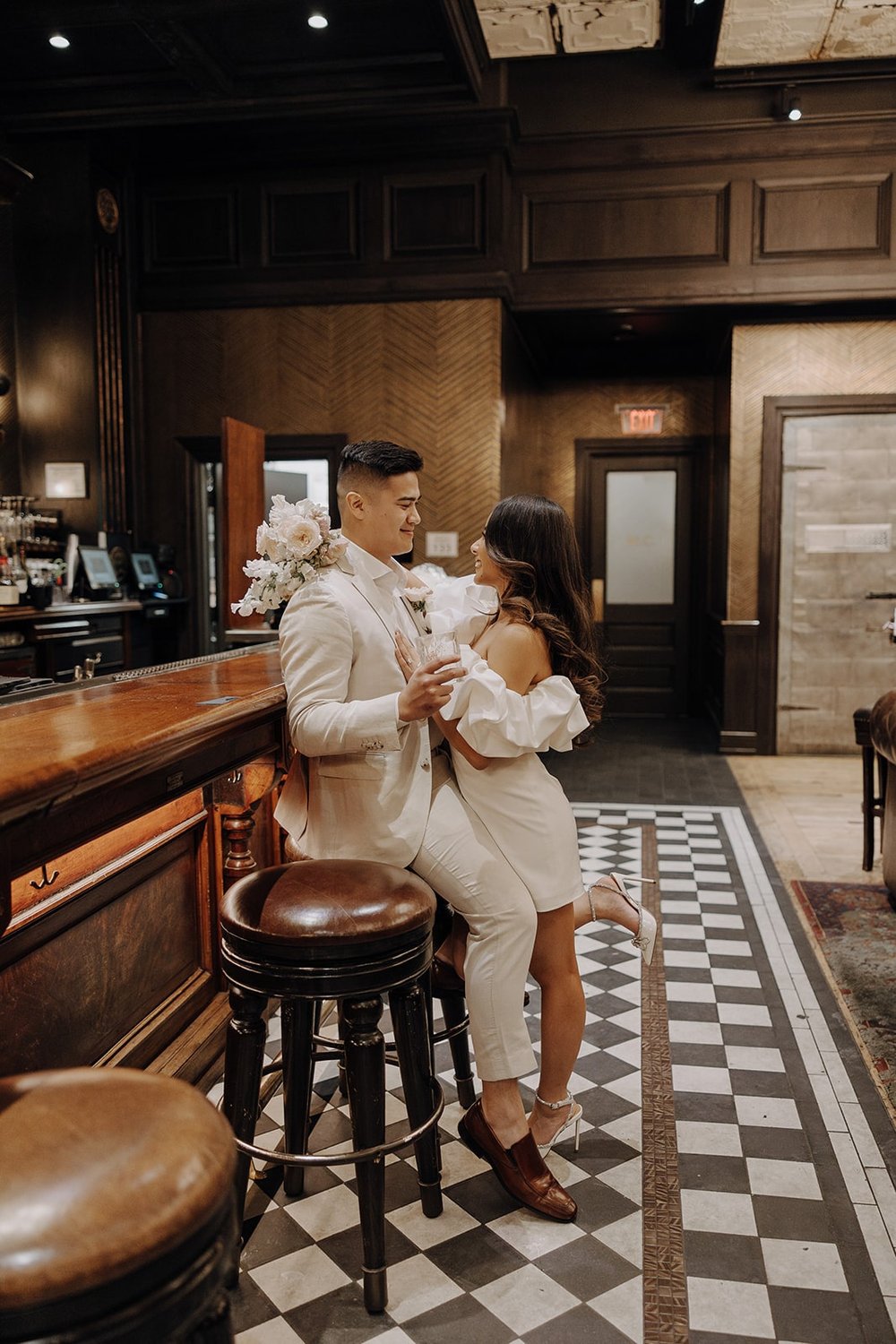 Bride and groom sit at a speakeasy bar during their Las Vegas elopement photos at the Cosmopolitan