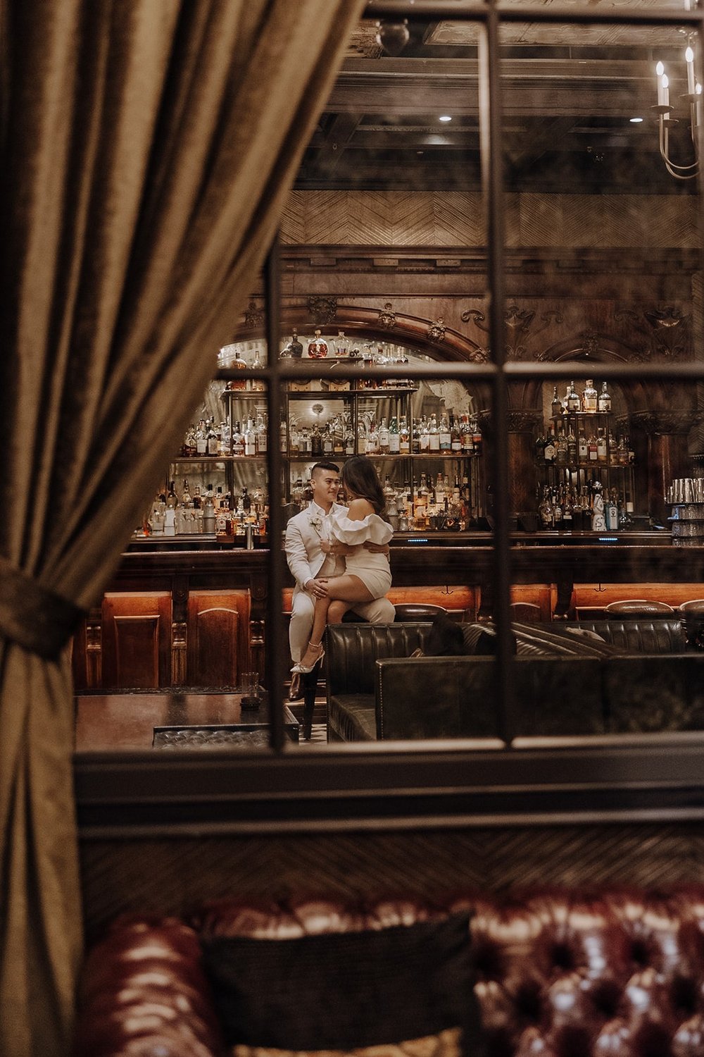 Bride and groom sit at a speakeasy bar during their Las Vegas elopement photos at the Cosmopolitan