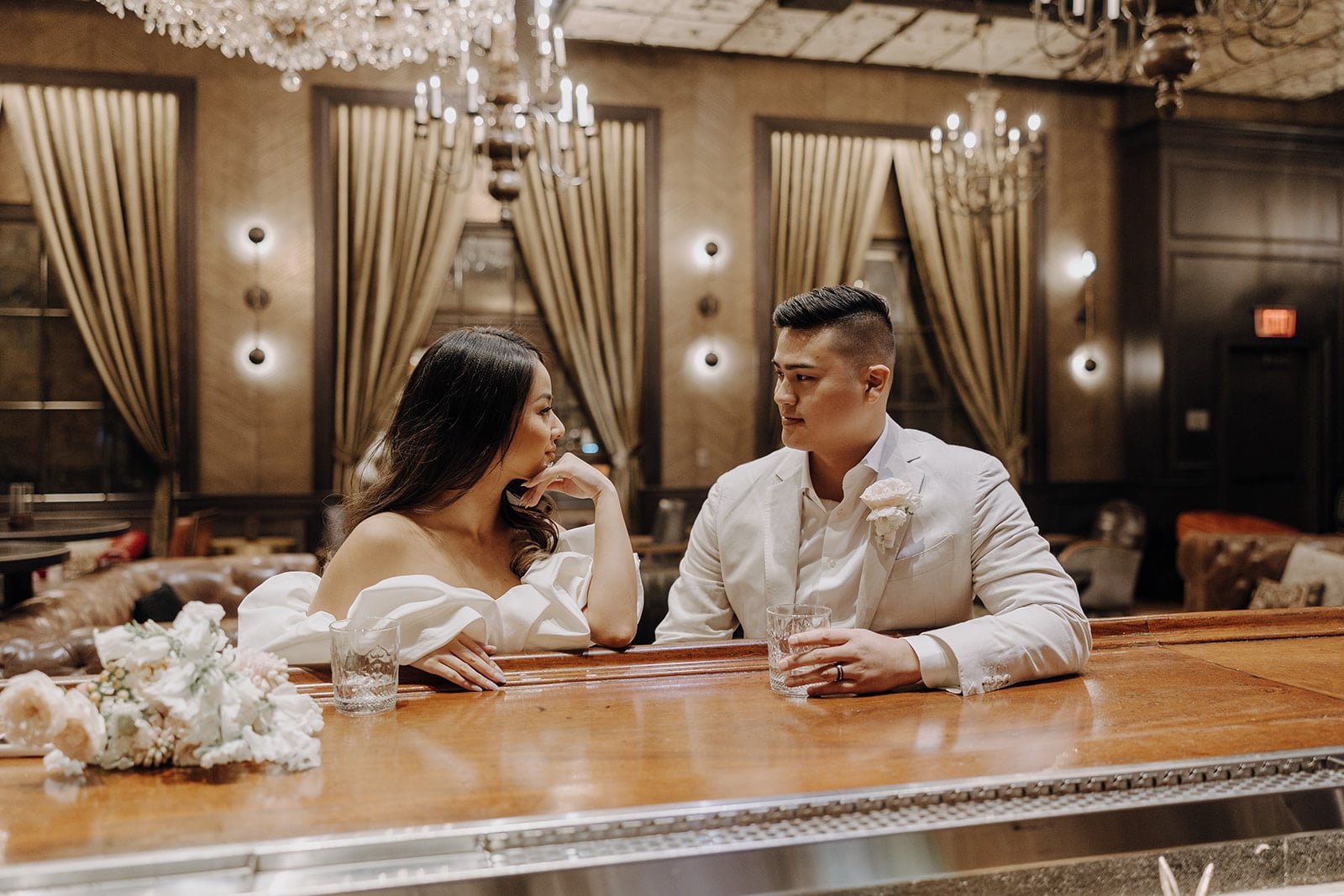 Bride and groom sit at a bar at the Cosmopolitan hotel during their elopement photos