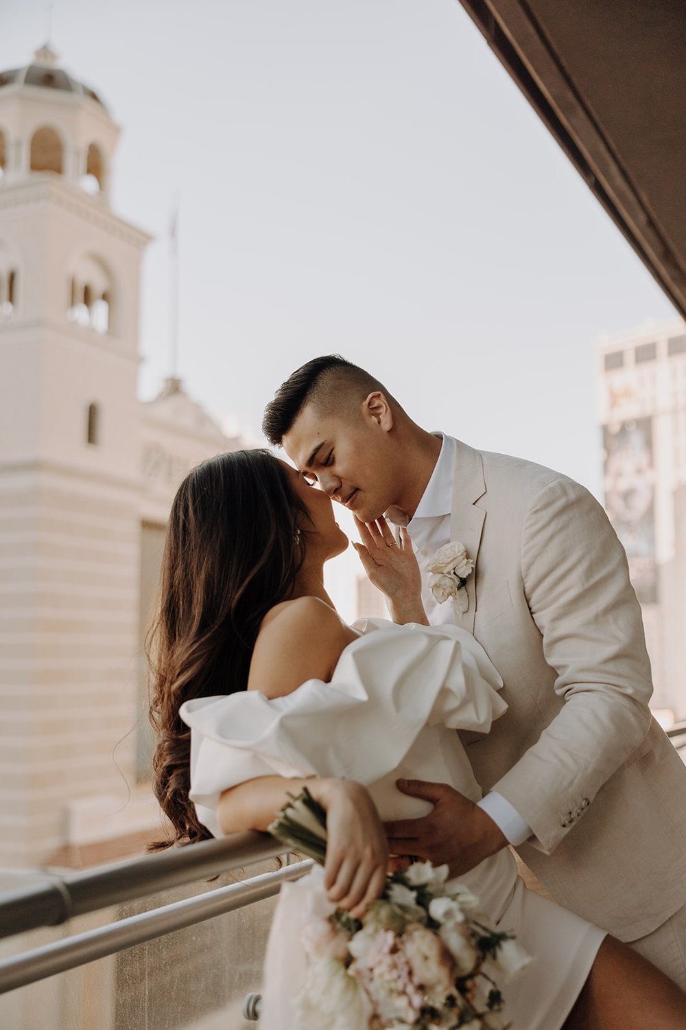 Bride and groom kiss on their hotel balcony during their Las Vegas elopement