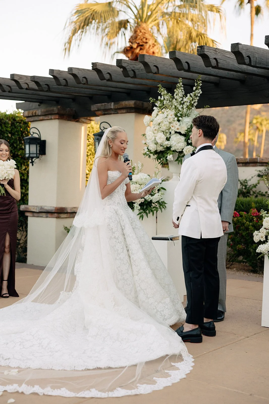 Outdoor wedding ceremony with seated guests, floral arrangements, and mountain scenery in the background under a clear sky for a luxury wedding