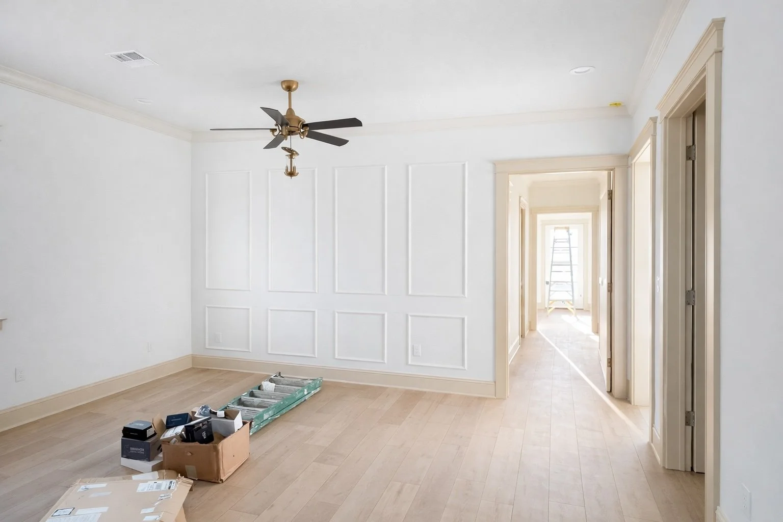 Wide-angle interior view showcasing custom door trim and beige baseboards with detailed wall panel molding, professionally finished trim carpentry with clean lines and seamless transitions.