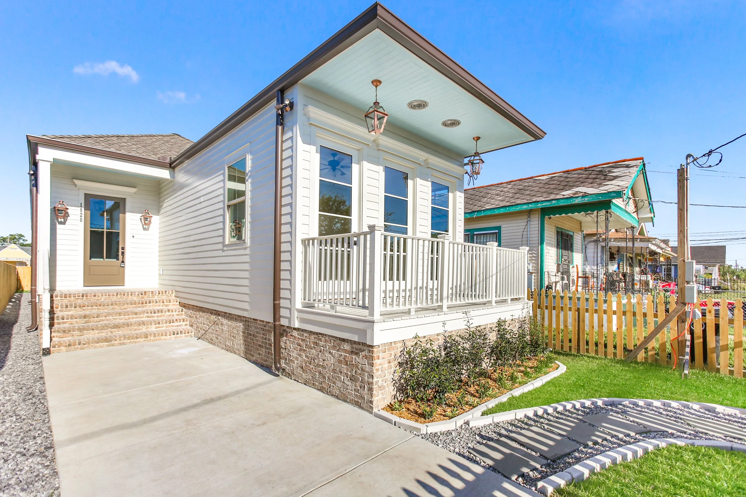 New construction home in New Orleans featuring a modern cottage exterior, raised foundation, covered front porch, and custom finishes.
