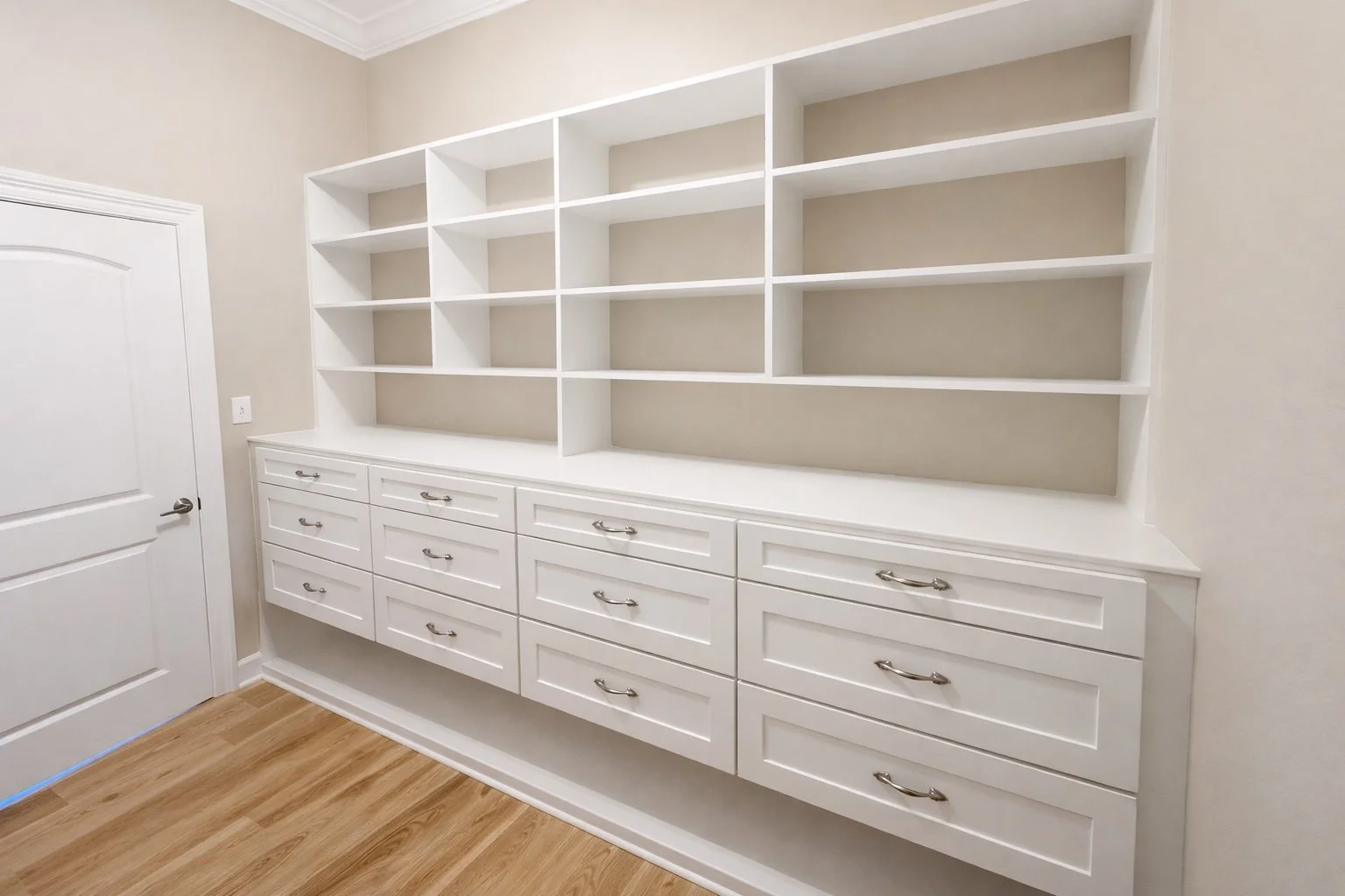 Detailed trim carpentry in a custom built-in closet with seamless shelving, flush drawer fronts, and clean painted millwork