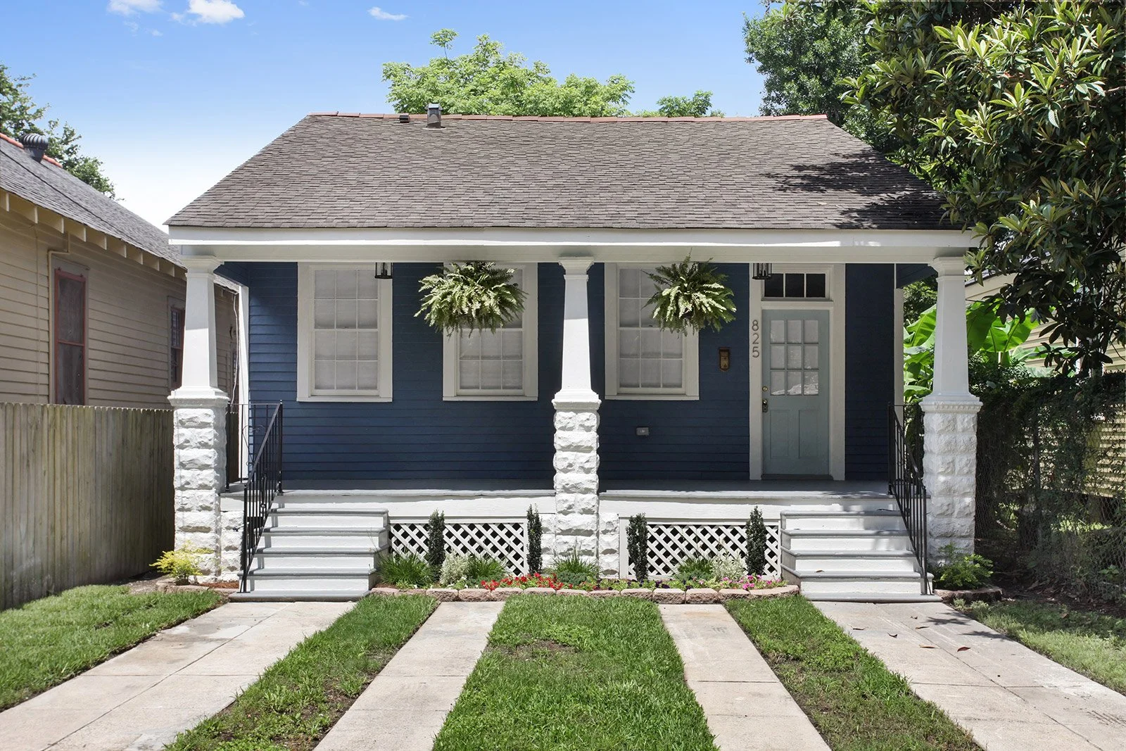 remodel cottage-style home in New Orleans featuring a covered front porch, custom columns, and modern exterior finishes
