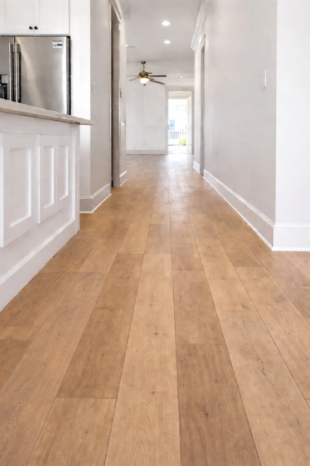 Continuous hardwood flooring installed seamlessly around the kitchen island with matching plank direction and finish.