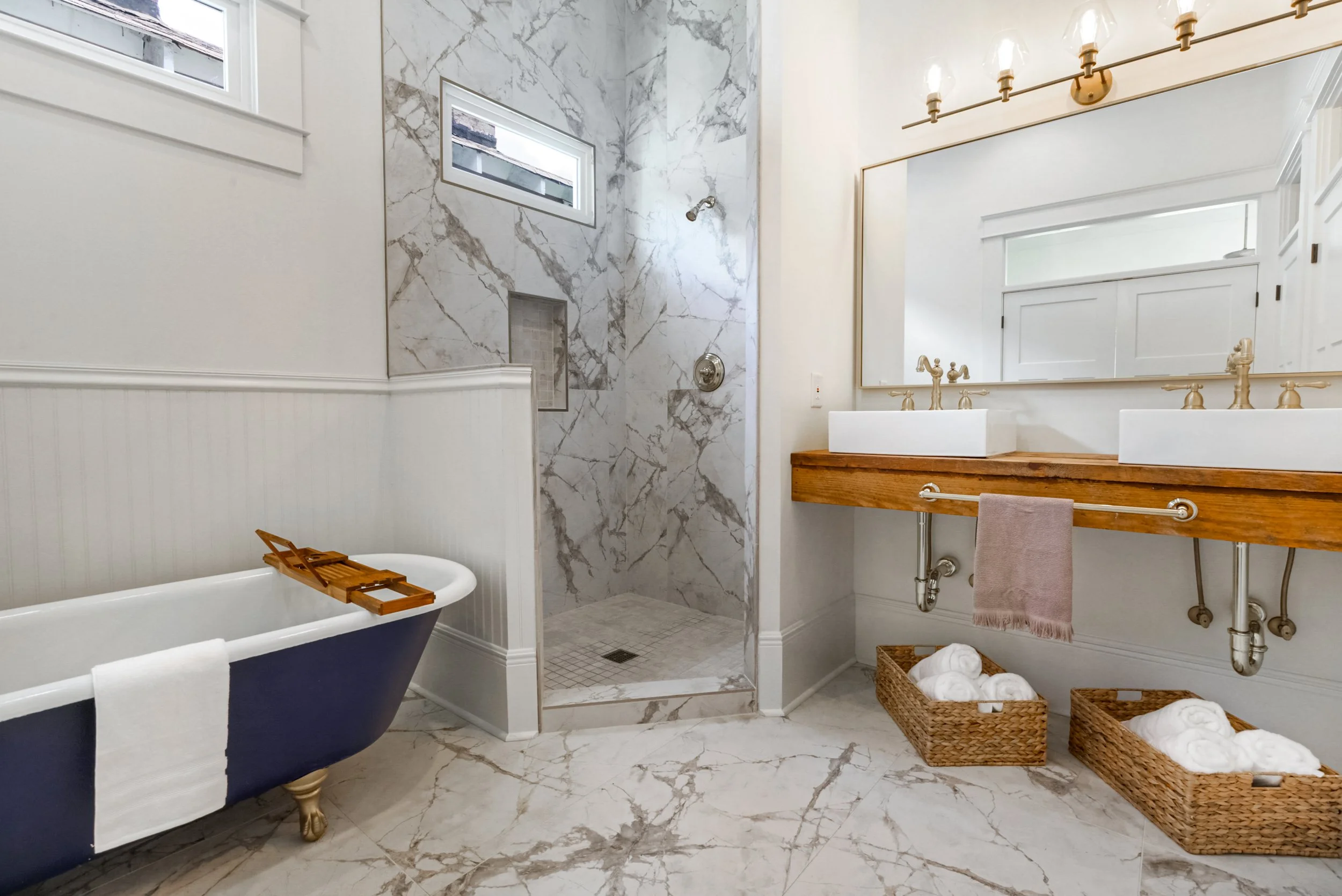 Luxury primary bathroom remodel featuring freestanding soaking tub, marble walk-in shower, dual vessel sinks, and custom wood vanity.