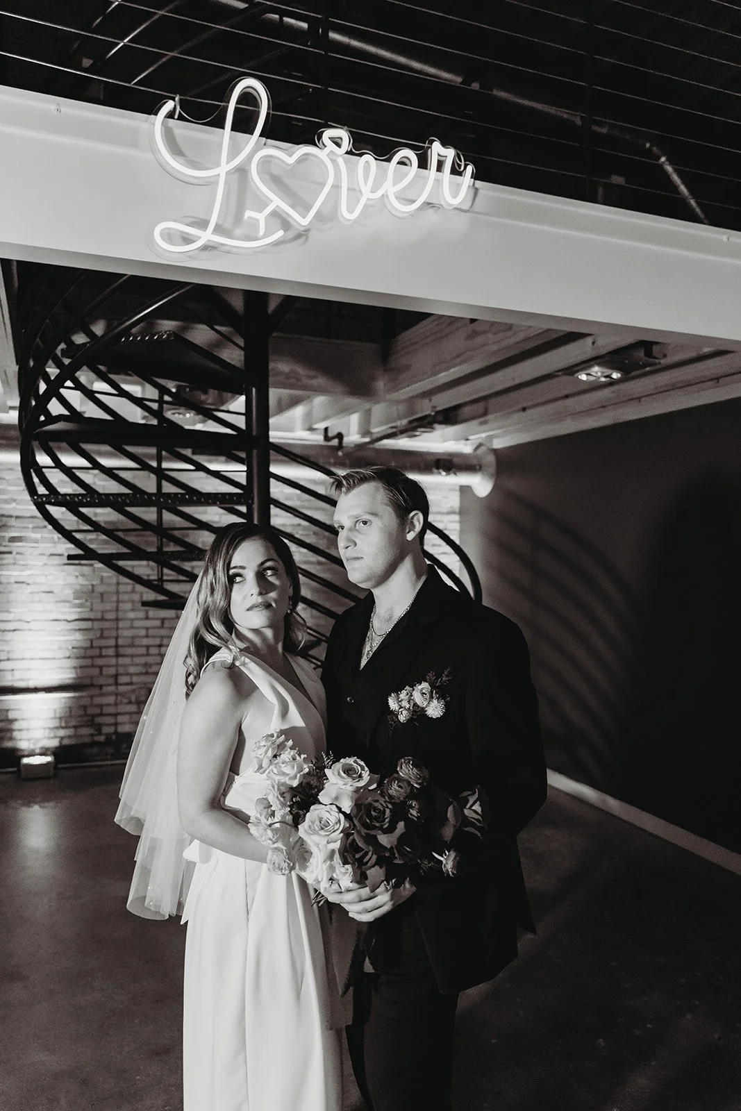 Industrial warehouse wedding venue at Studio 215 in Fayetteville, NC, located near Raleigh and Fort Bragg, featuring exposed brick, bistro lighting, and a modern chic aesthetic for weddings and events. 