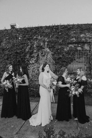 Bride and groom posing in front of the signature green ivy wall at Studio 215 in downtown Fayetteville, NC; a lush urban garden photography backdrop at our industrial warehouse venue near Fort Bragg and Raleigh.