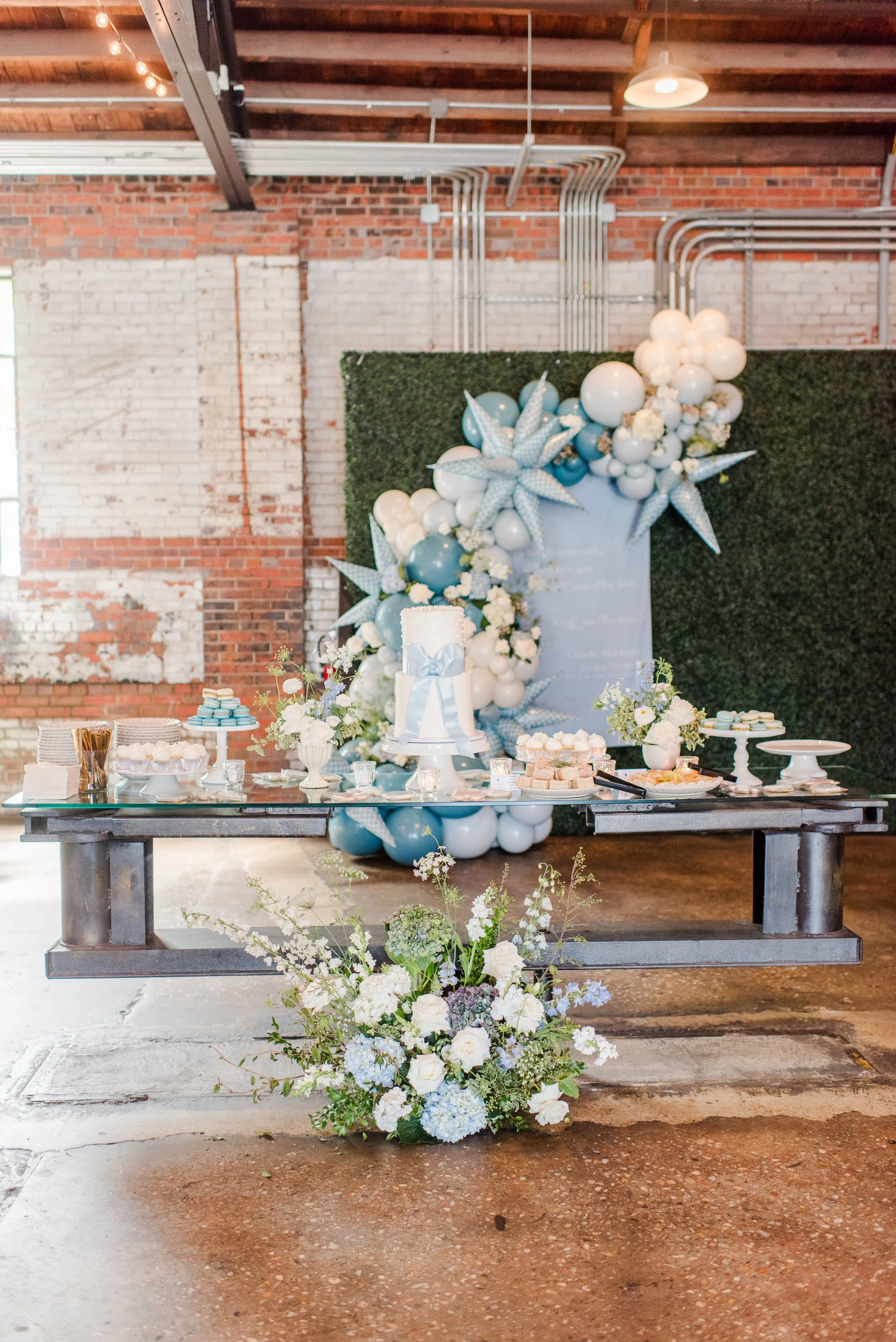 A large industrial wedding ceremony space at Studio 215 in Fayetteville, NC, featuring original 1937 exposed brick walls, vaulted wood ceilings, and steel cross-bow beams.