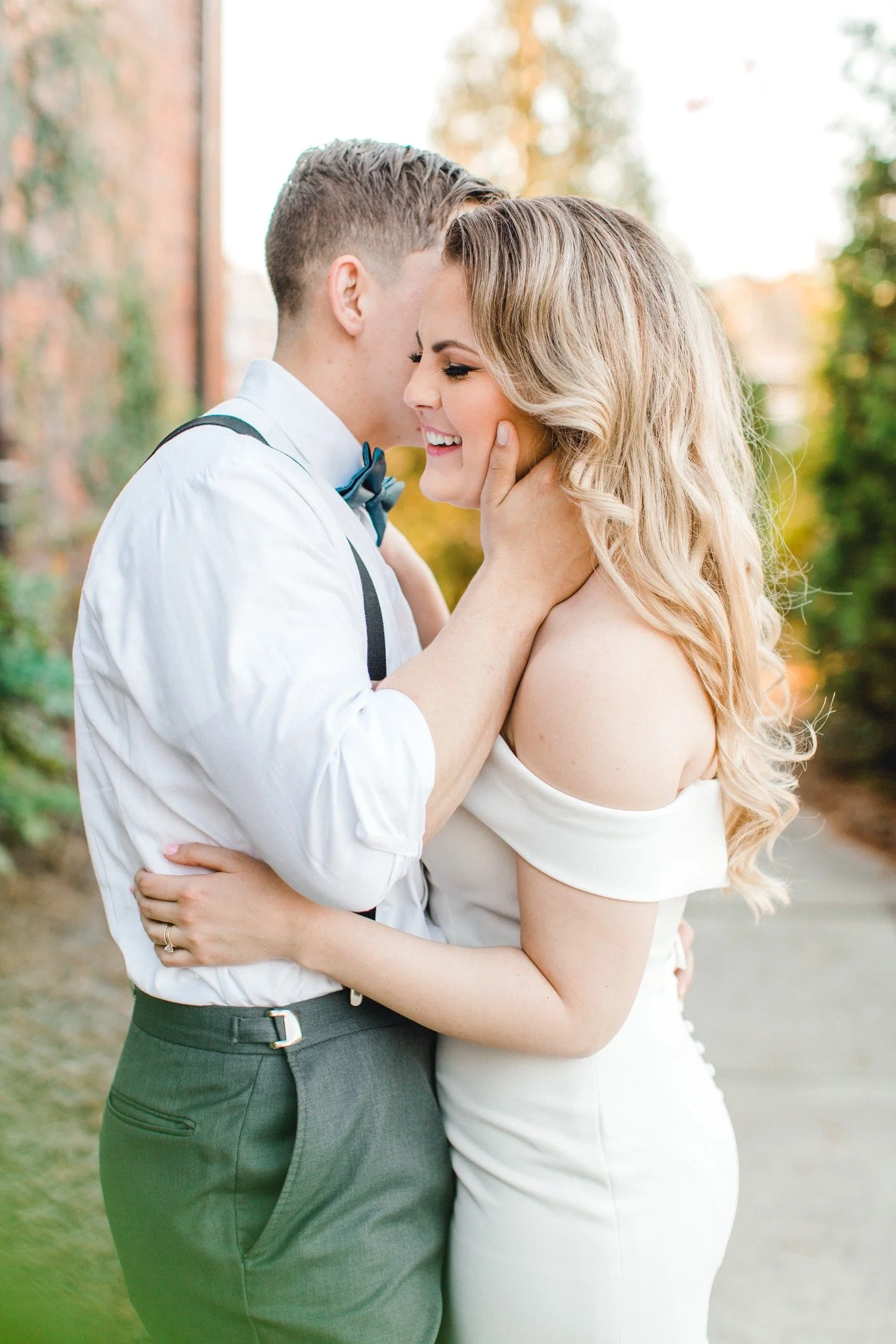 Bride and groom posing in front of the signature green ivy wall at Studio 215 in downtown Fayetteville, NC; a lush urban garden photography backdrop at our industrial warehouse venue near Fort Bragg and Raleigh.