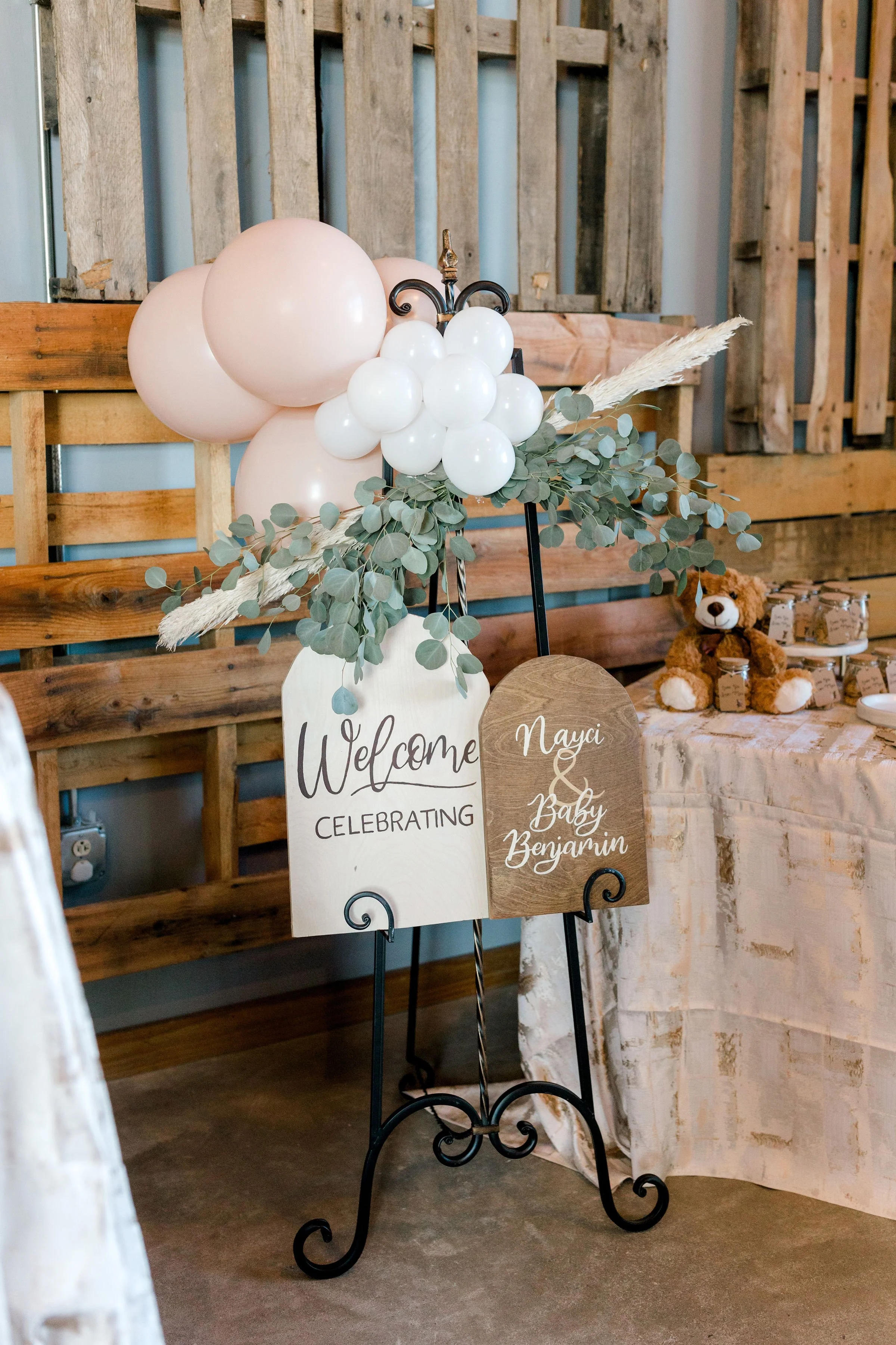 Welcome sign with balloons, greenery, and rustic decor for a celebration of baby Benjamin.