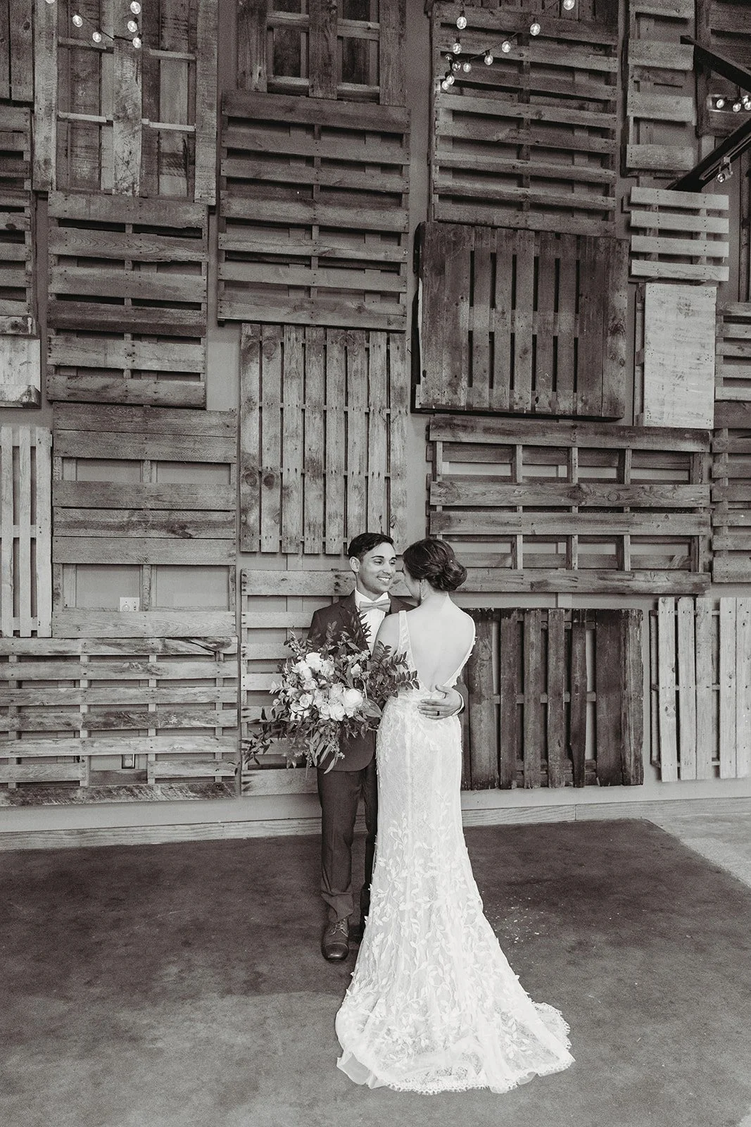 Industrial warehouse wedding venue at Studio 215 in Fayetteville, NC, located near Raleigh and Fort Bragg, featuring exposed brick, bistro lighting, and a modern chic aesthetic for weddings and events. 