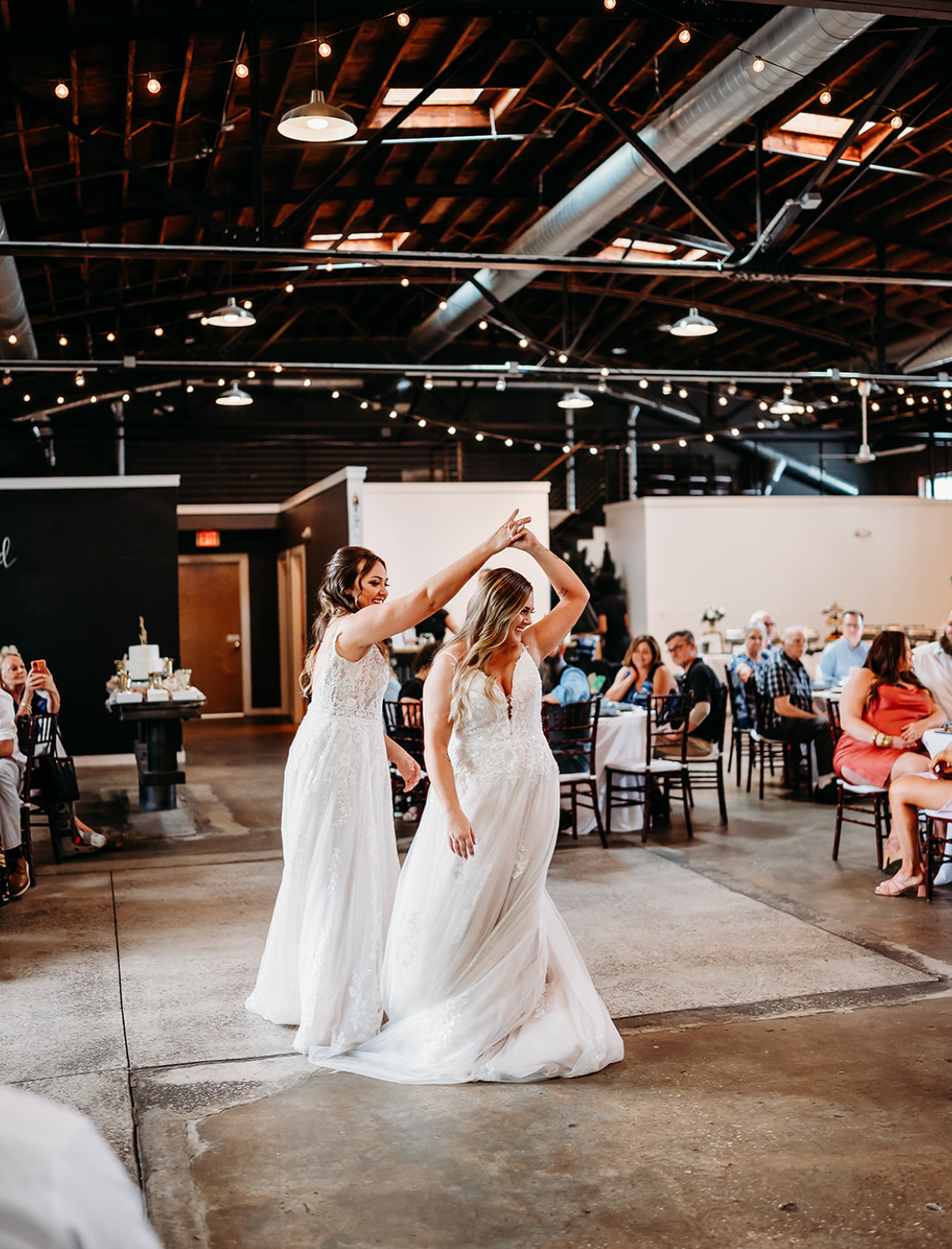 Industrial warehouse wedding venue at Studio 215 in Fayetteville, NC, located near Raleigh and Fort Bragg, featuring exposed brick, bistro lighting, and a modern chic aesthetic for weddings and events. 