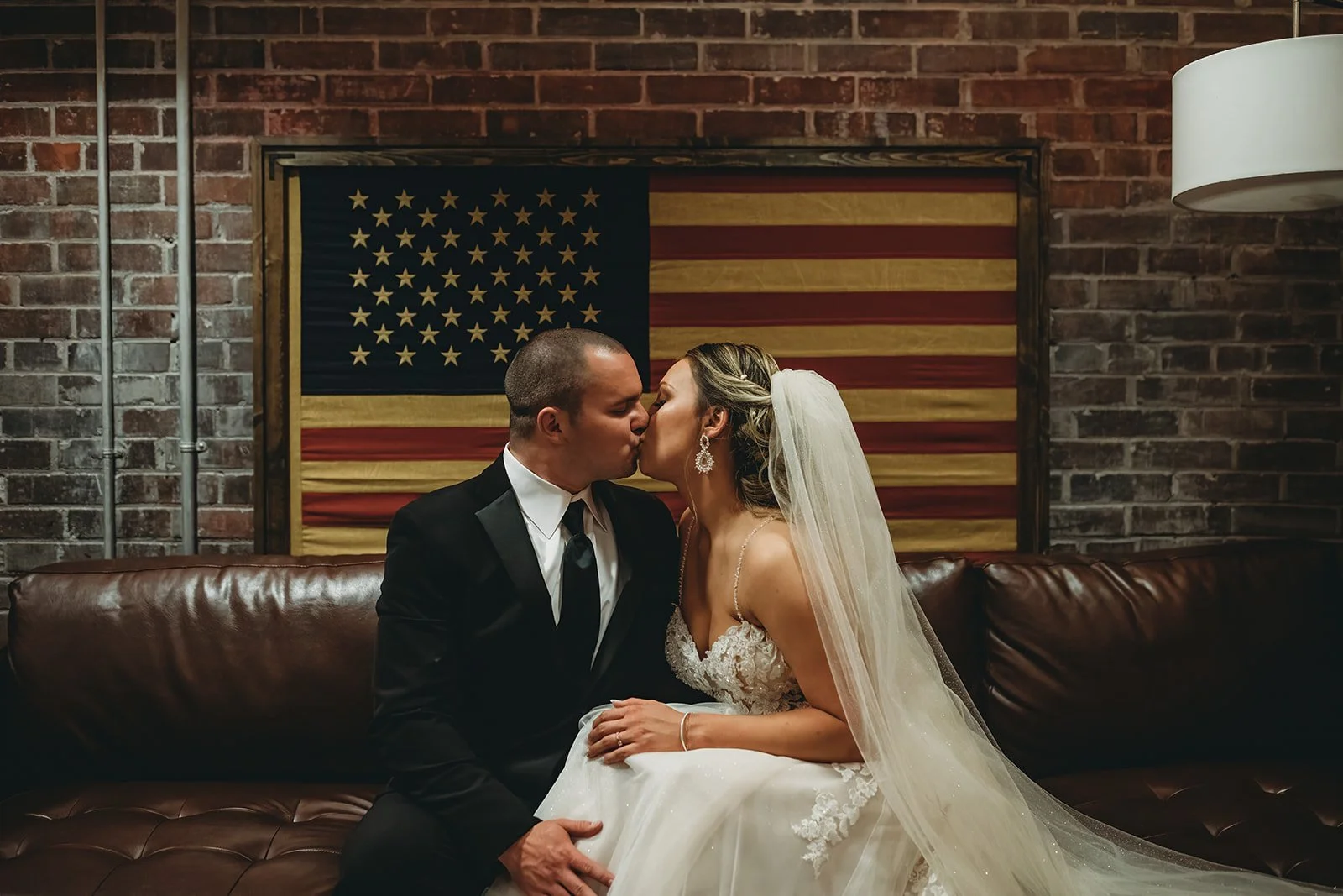 Industrial warehouse wedding venue at Studio 215 in Fayetteville, NC, located near Raleigh and Fort Bragg, featuring exposed brick, bistro lighting, and a modern chic aesthetic for weddings and events. 