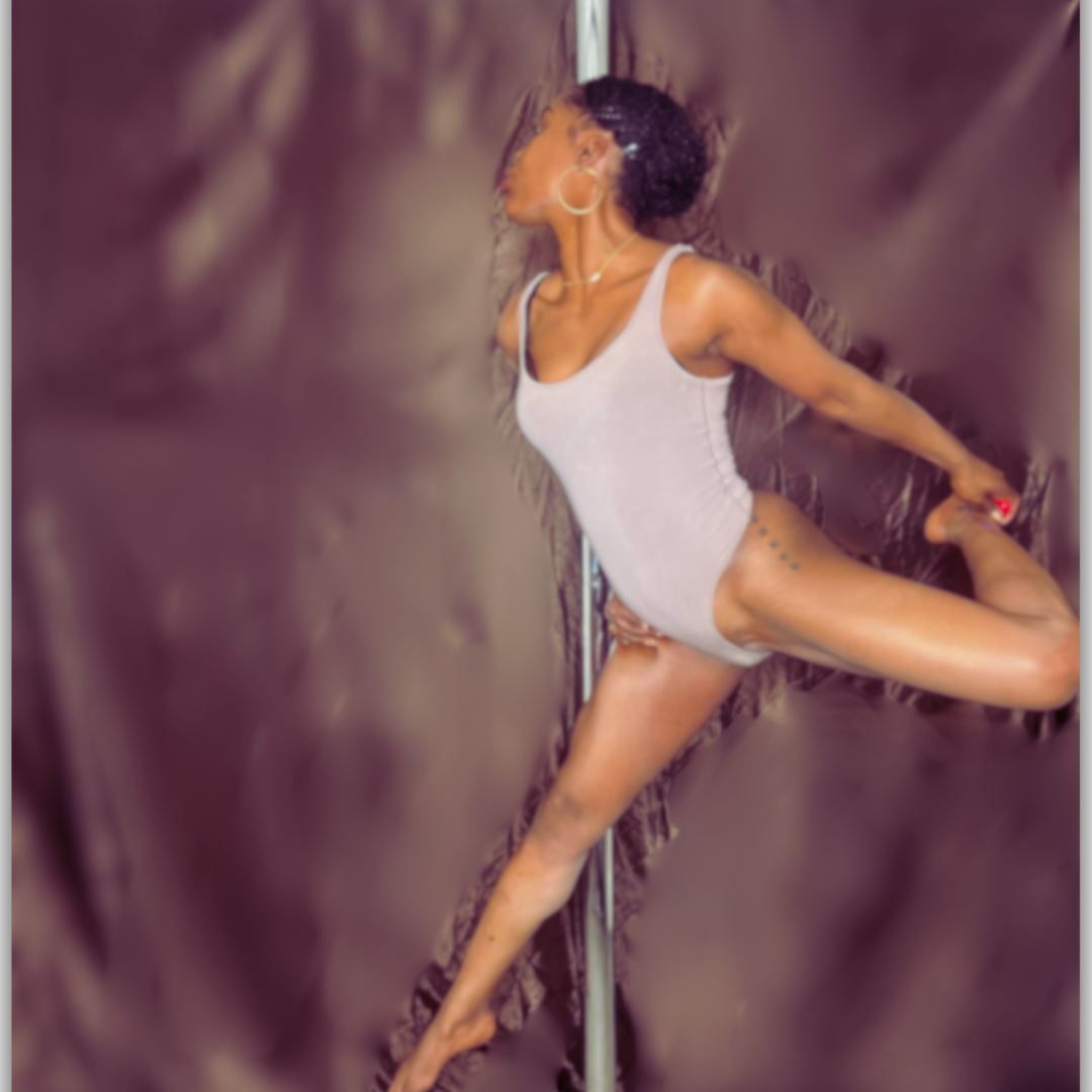 A woman practicing pole dance, performing a pose on a pole, wearing a white tank top, with her hair in a messy bun and tattoos on her side.