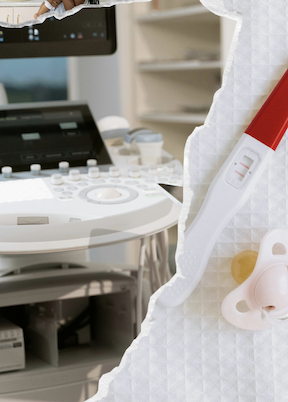 Ultrasound machine in a fertility clinic beside a positive pregnancy test and baby pacifier, illustrating the journey from a DOR diagnosis to building a family through egg donation IVF.