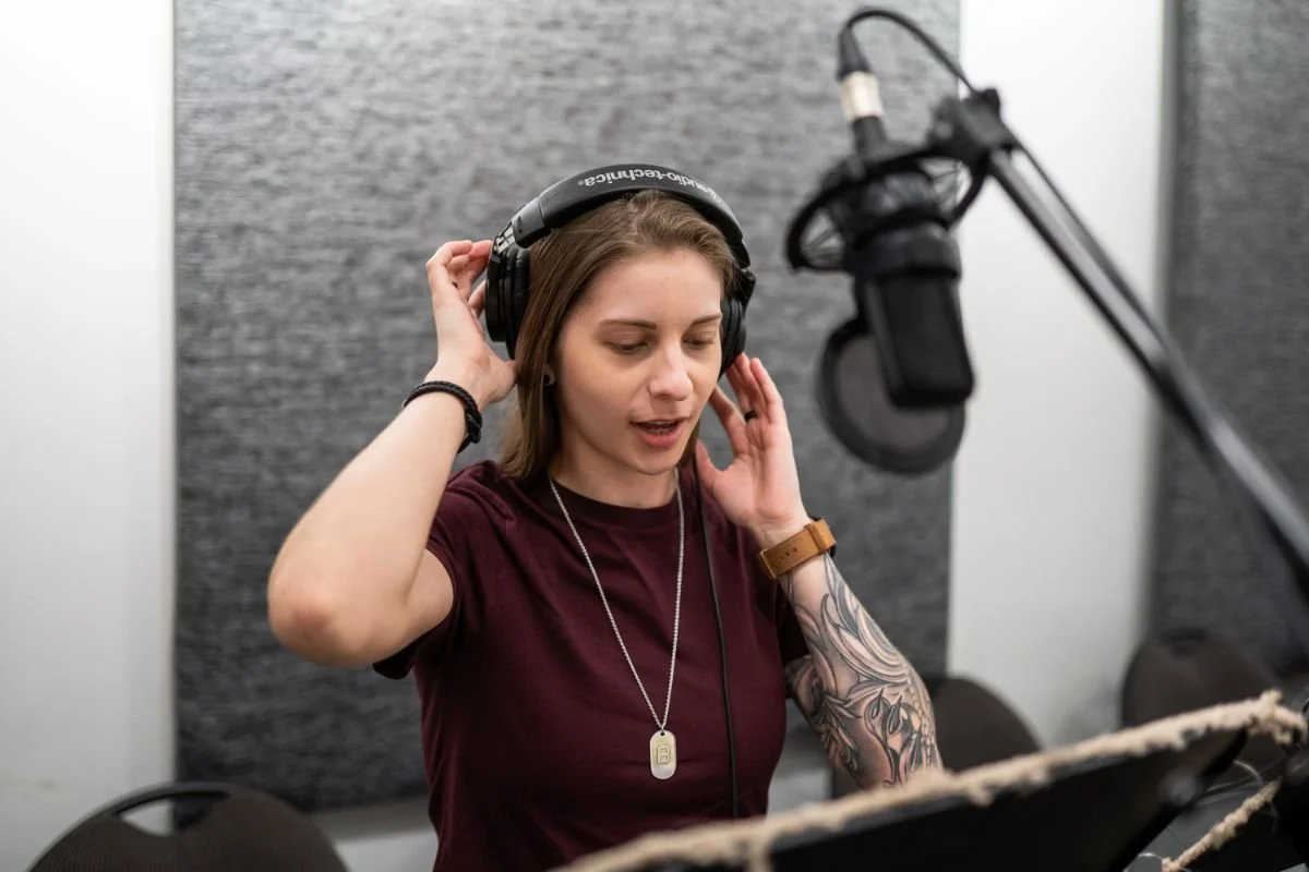 Woman wearing headphones performing at a studio microphone during an Animation Voice-Over Level 1 class