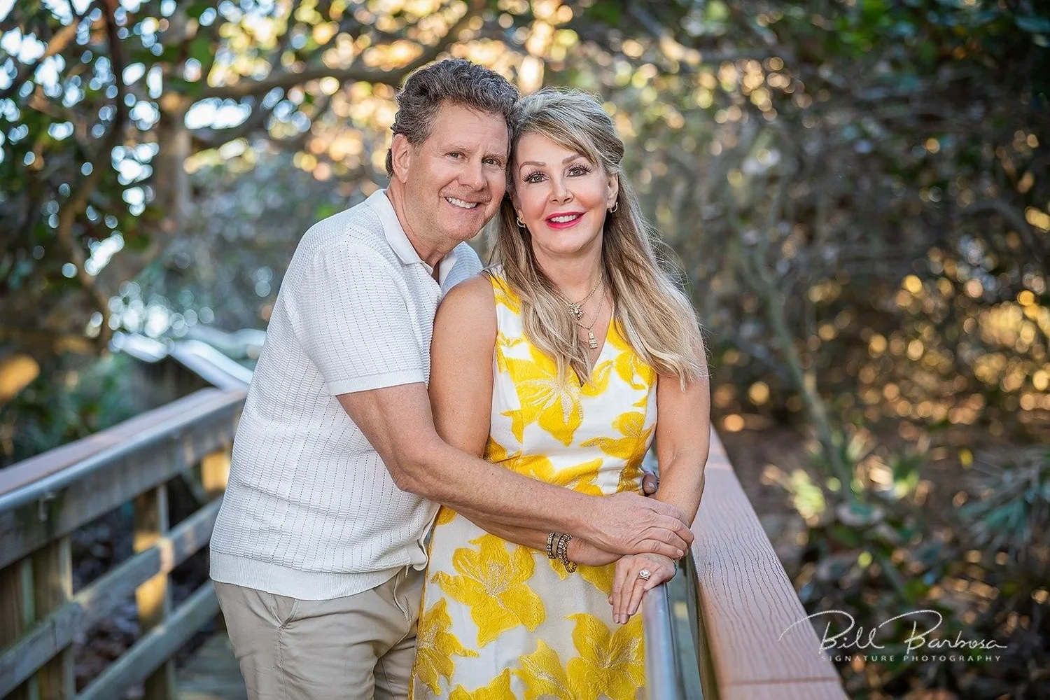 Couple smiling together on a wooden walkway.