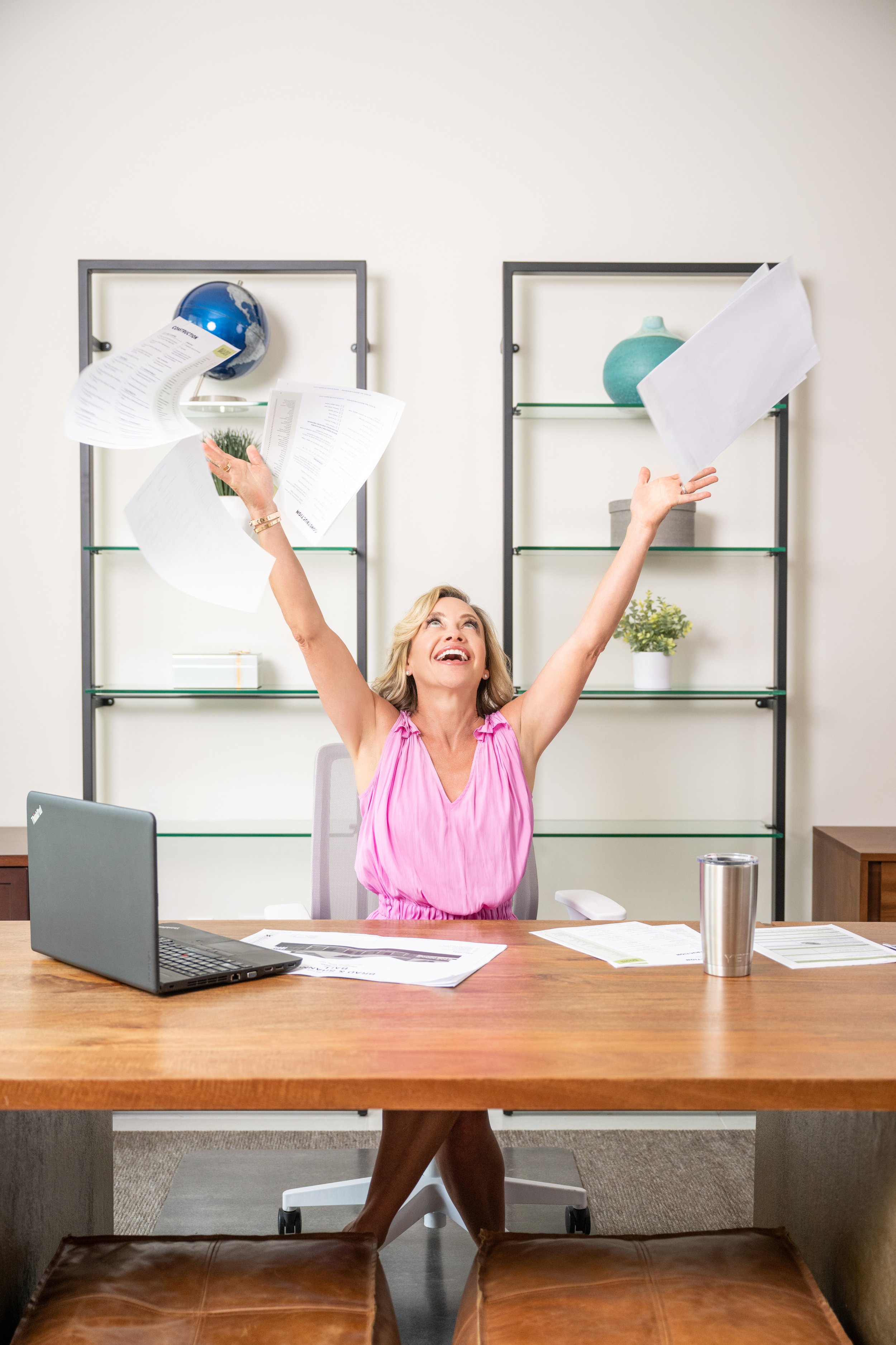 Personal branding photography for a woman throwing her pages in the air in joy