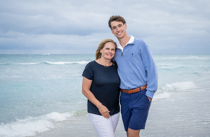 Woman and young man smiling by the ocean.
