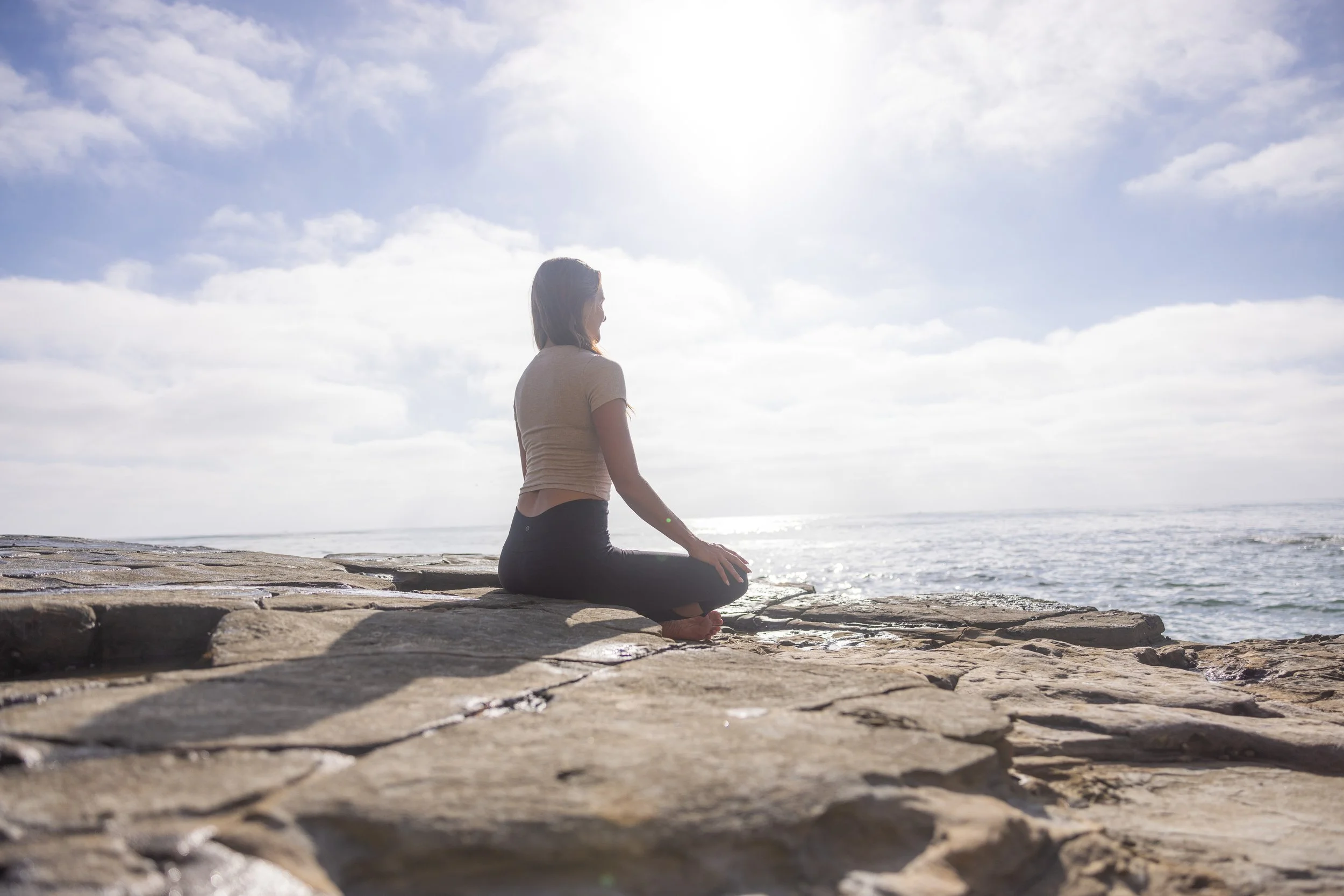 Josie Kramer practicing embodied movement for nervous system regulation on the beach