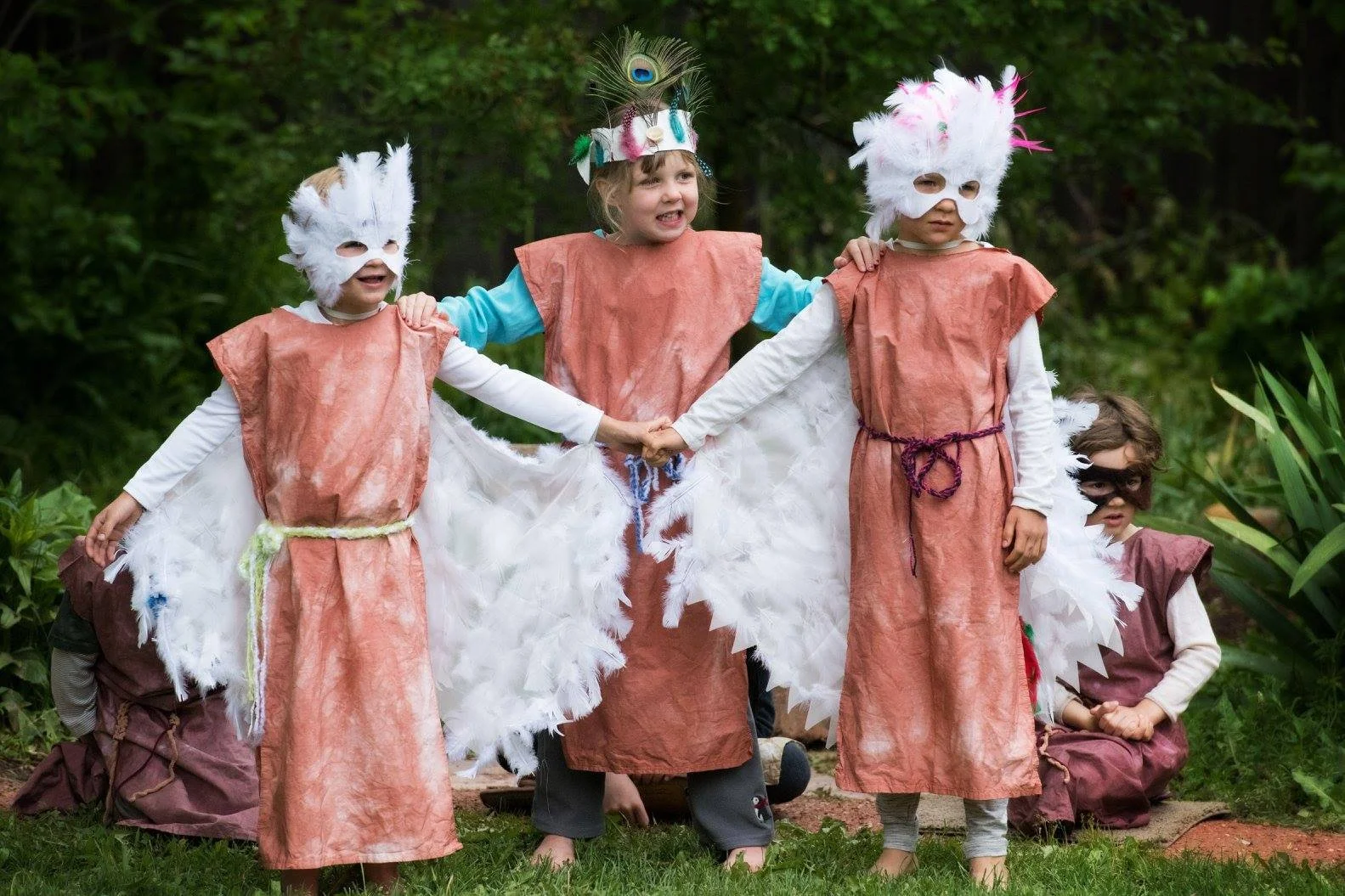 Three children dressed in costume, performing The Earth On Turtle's Back play at Sage Programs n Boulder Colorado.