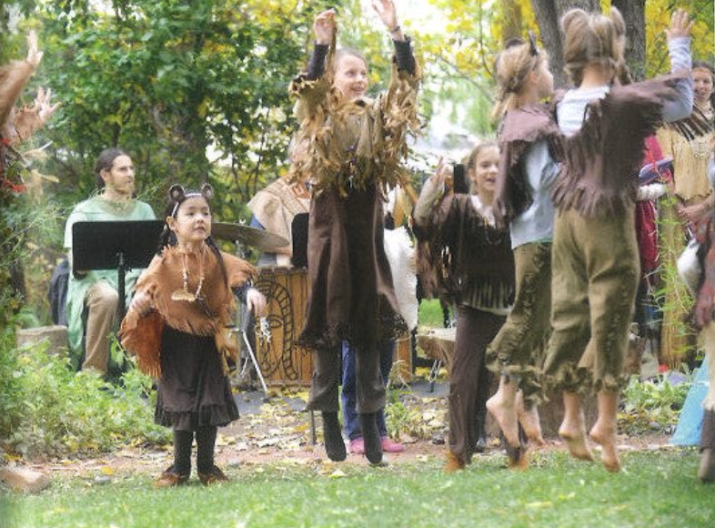 Children dressed as animals and characters performing outdoors with adults, surrounded by trees and autumn leaves. This is the performance of the Jumping Mouse Play at Sage Programs, in Boulder Colorado.