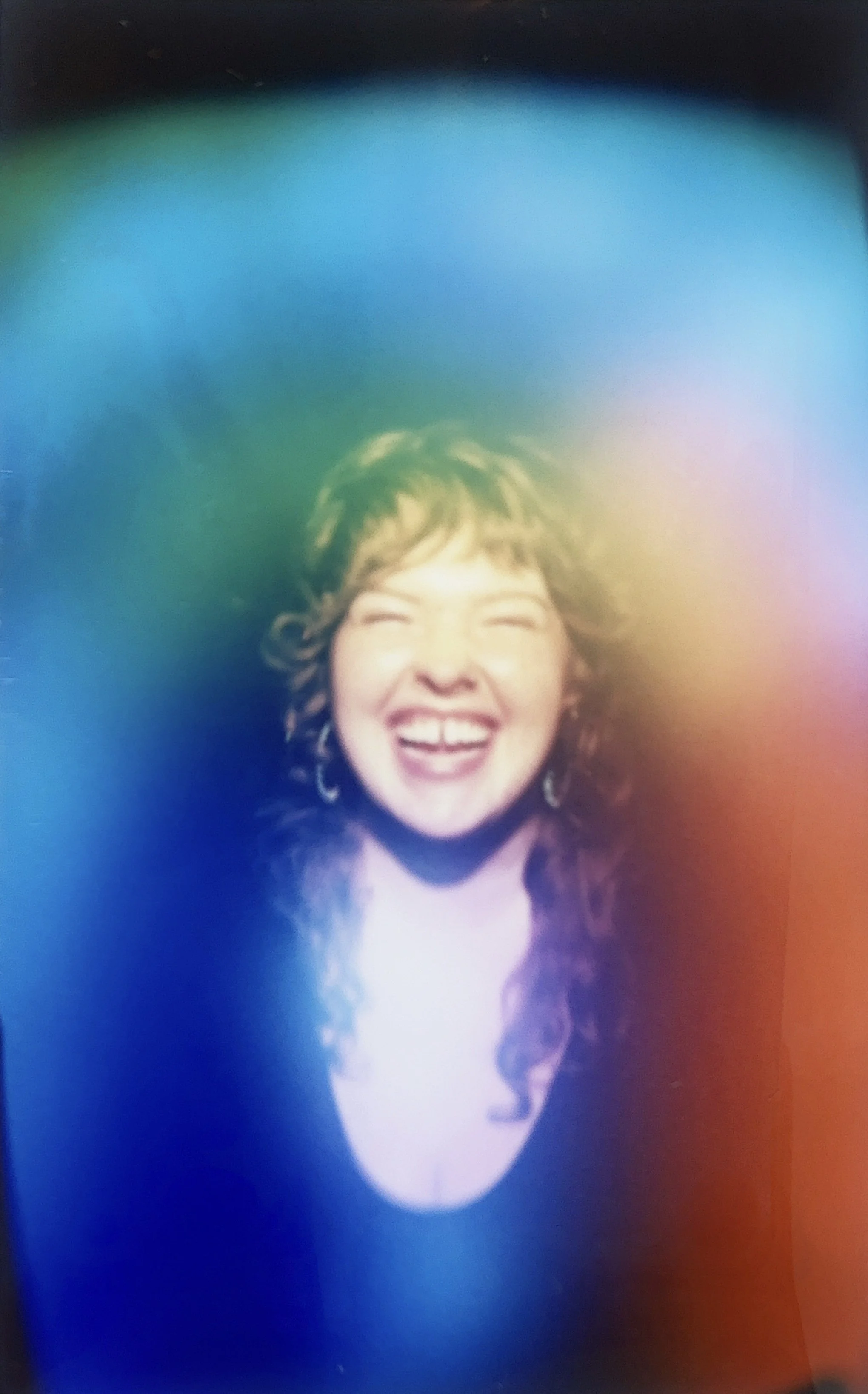 Bryleigh McCary with Sage Programs laughing and smiling with curly hair, illuminated by multicolored light effects.