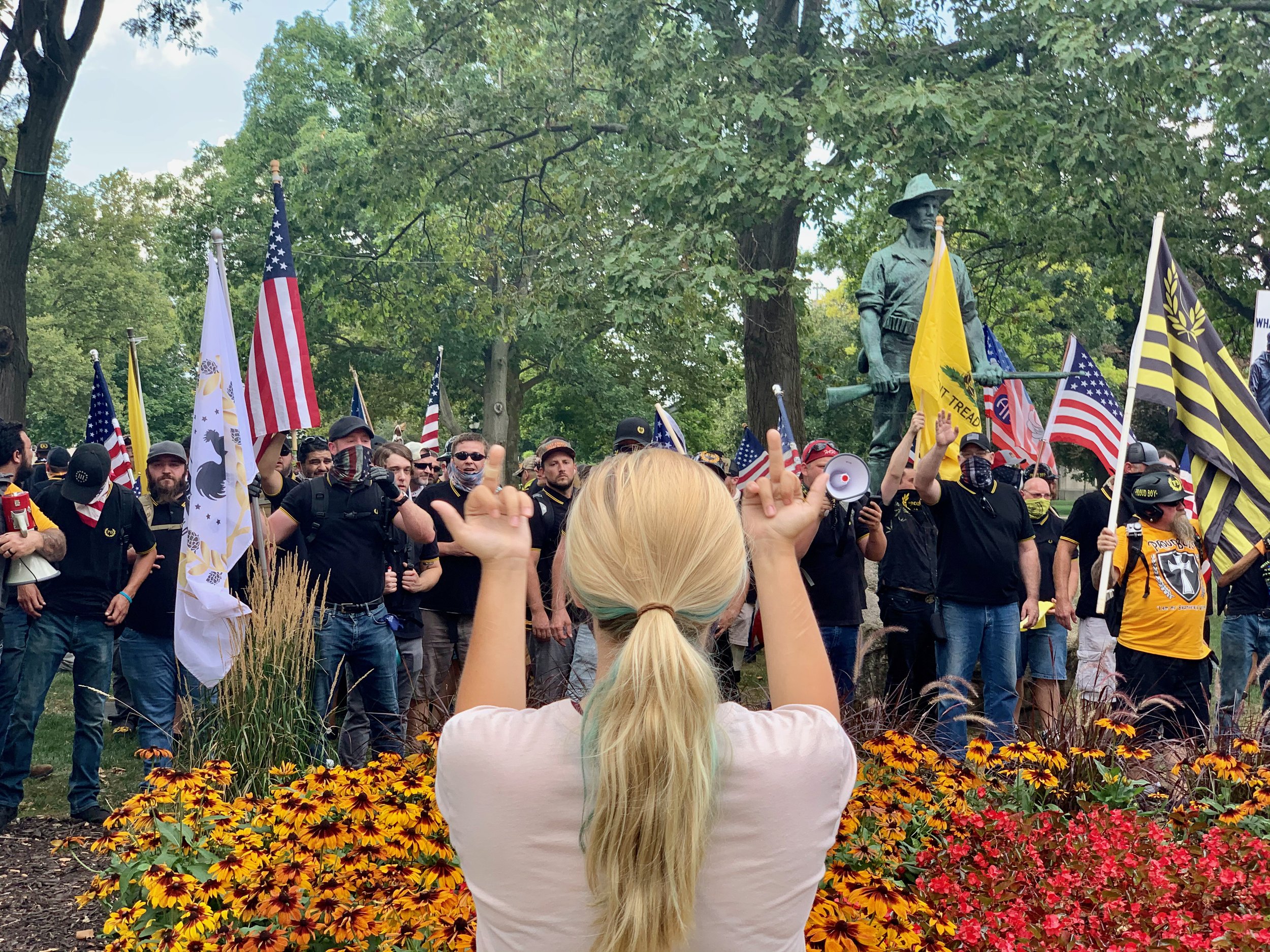 A protester gives two middle fingers to members of the White Supremacist group the Proud Boys, after they came to Kalamazoo from out of town to hold a rally on August 15, 2020.