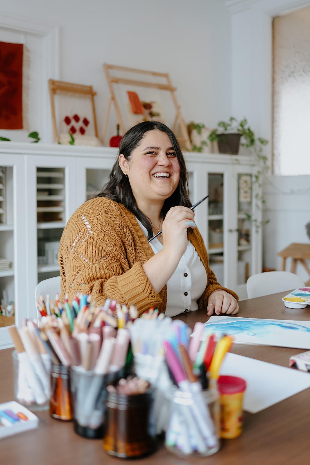 Elspeth smiling holding a paintbruch and having fun