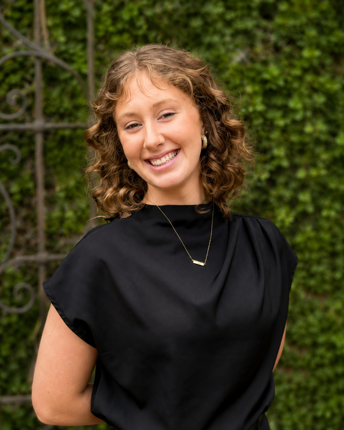 Woman with curly hair smiling and wearing a black shirt