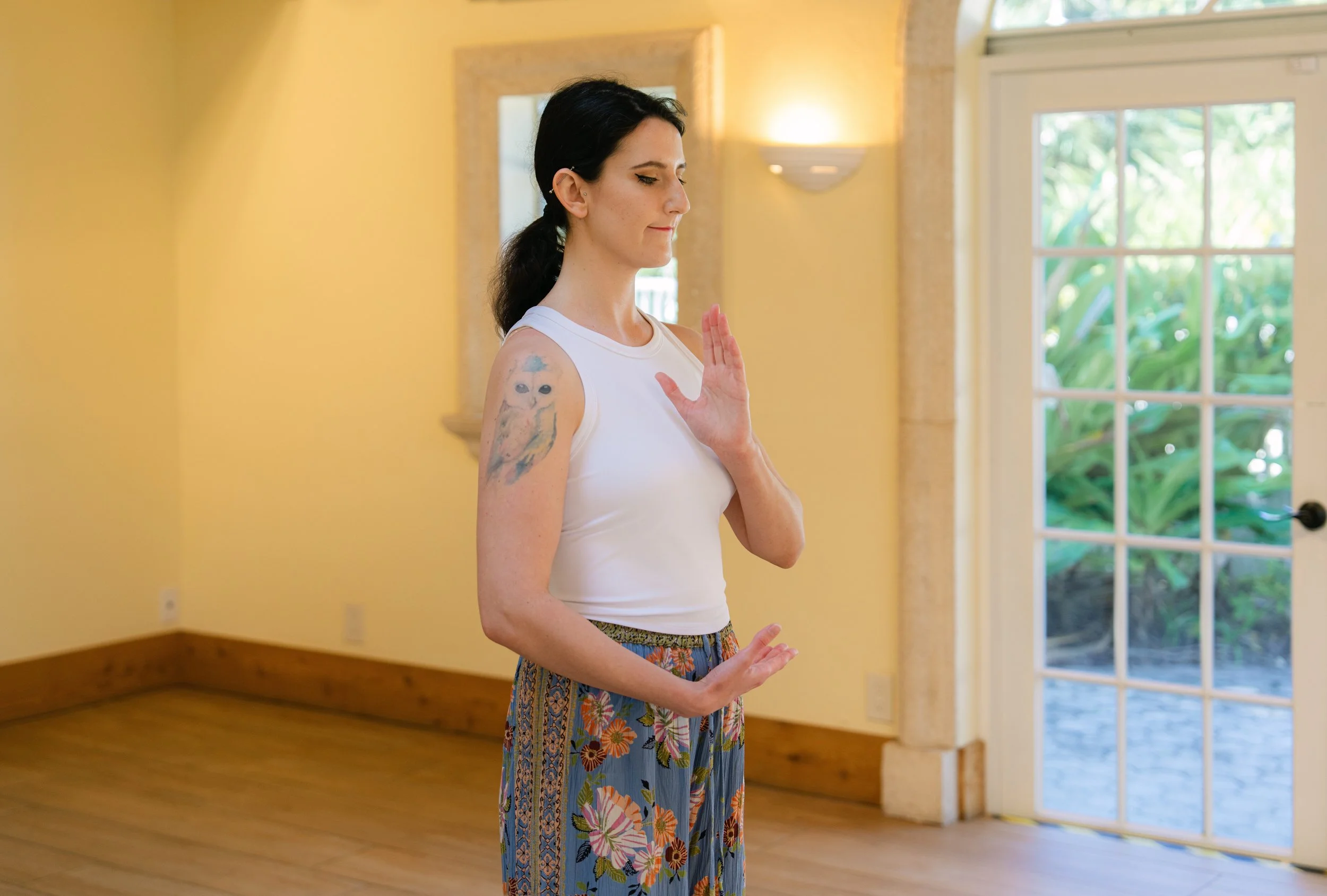 Made with Love founder, Winter, stands outside with her eyes closed, holding her hands palm-side up while in a meditative stance.